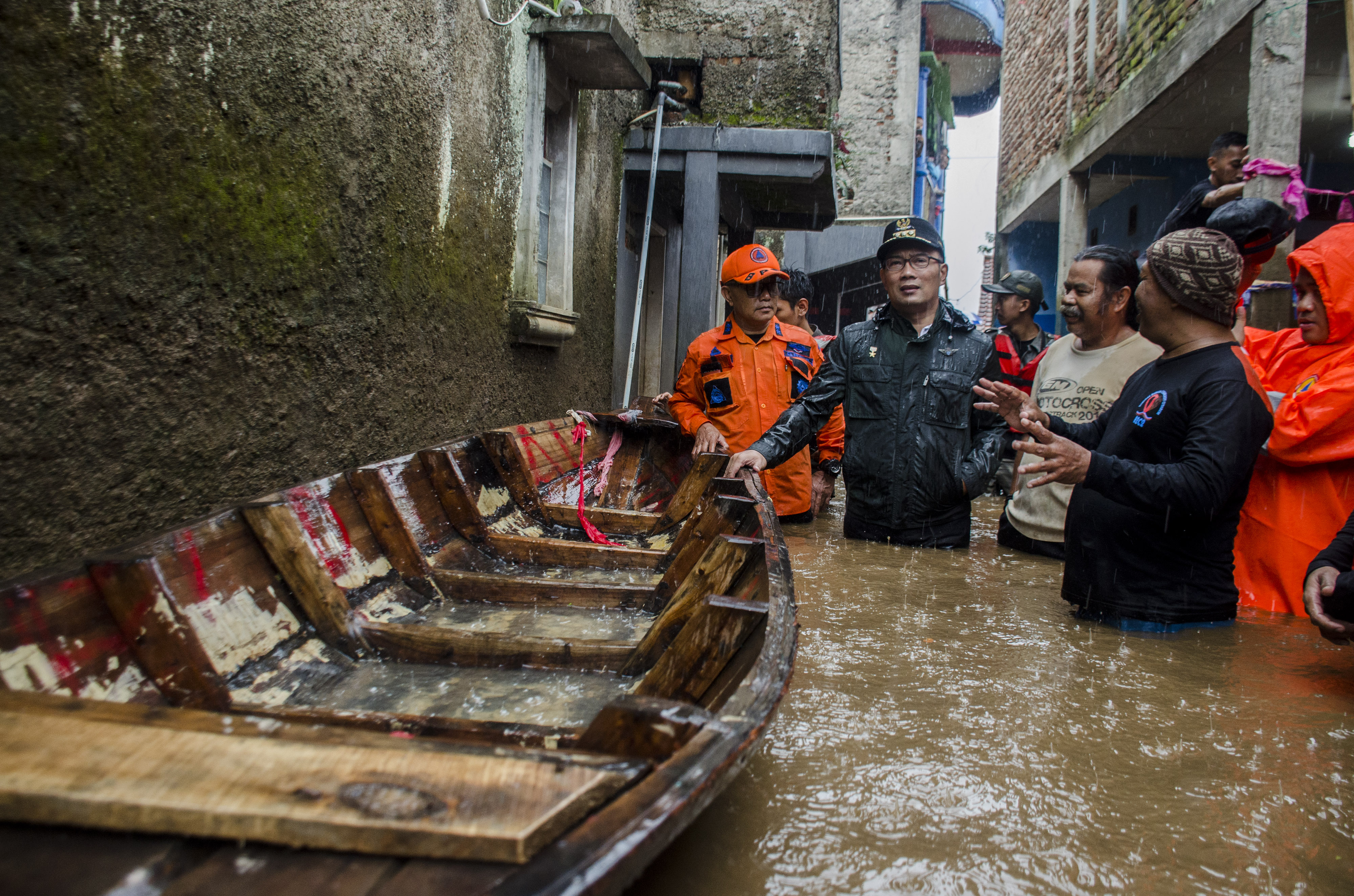 Gubernur Jawa Barat Ridwan Kamil (kedua kiri) berjalan melewati genangan saat meninjau lokasi banjir di kawasan Baleendah, Kabupaten Bandung