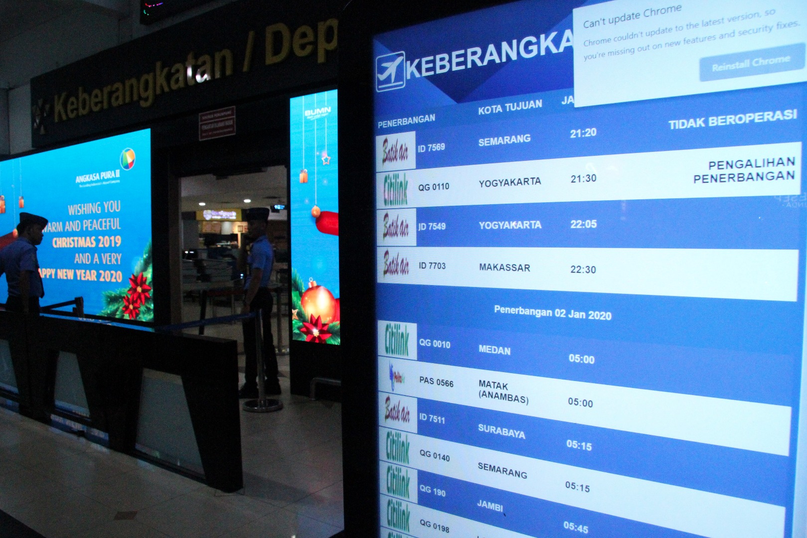 Petugas keamanan bandara berjaga di pintu keberangkatan Bandara Internasional Halim Perdanakusuma, Jakarta.