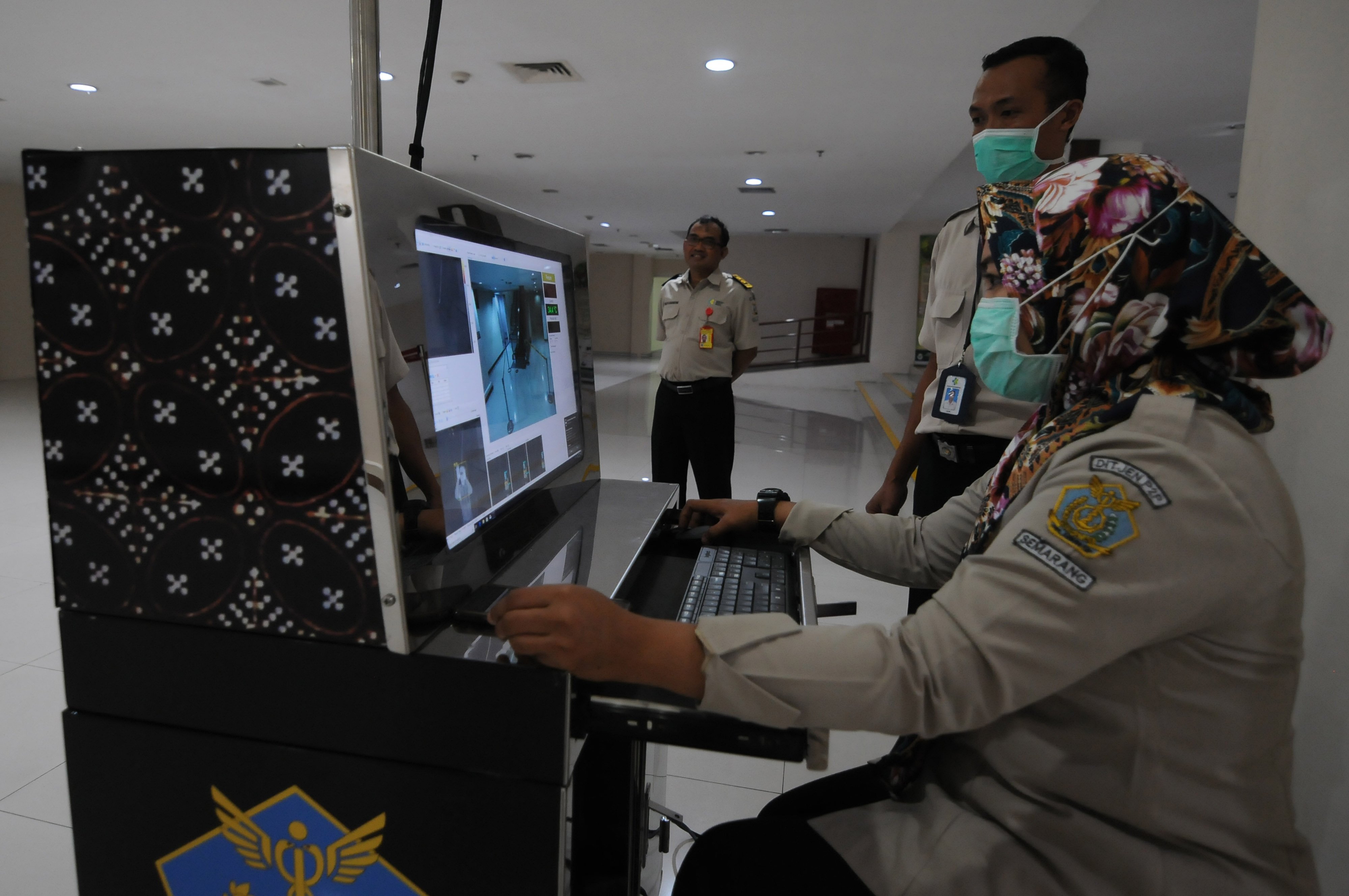 Pemantauan penumpang yang tiba di bandara, melalui thermo scanner sebagai upaya pengendalian virus korona. 