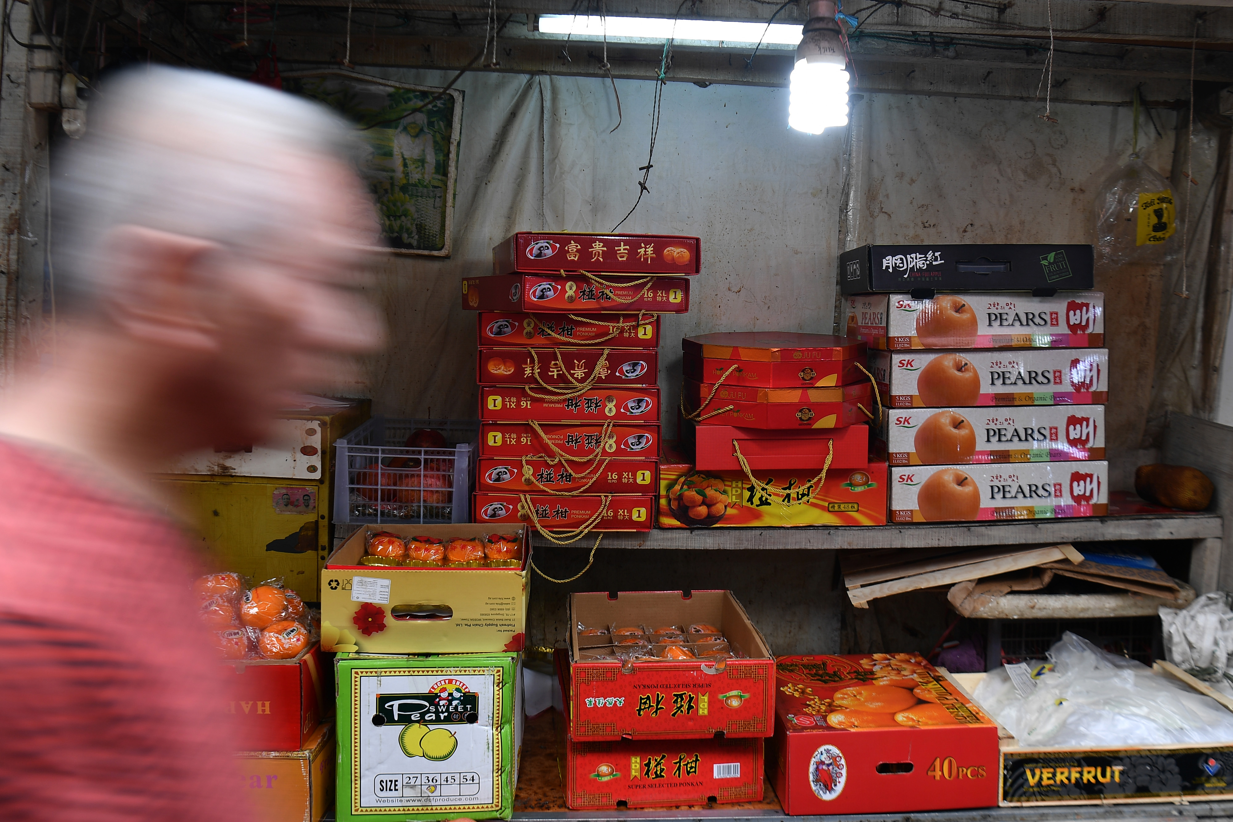  Warga melintas di dekat jeruk impor yang dijual di kawasan Glodok, Jakarta Barat, Senin (27/1/2020). 