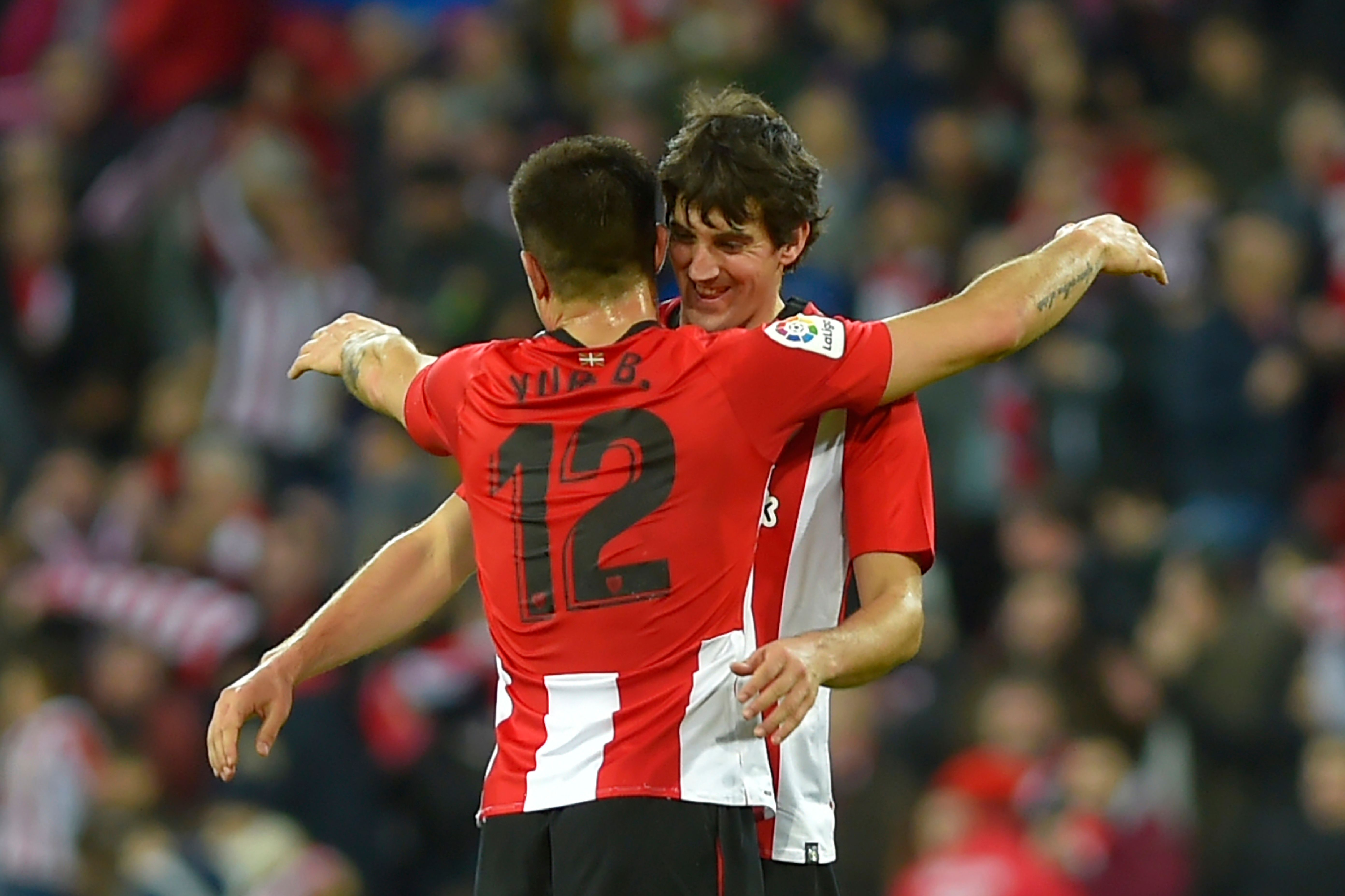 Bek Athletic Bilbao Yuri Berchiche (kiri) dan bek Mikel San Jose berangkulan saat Bilbao memenangi pertandingan.