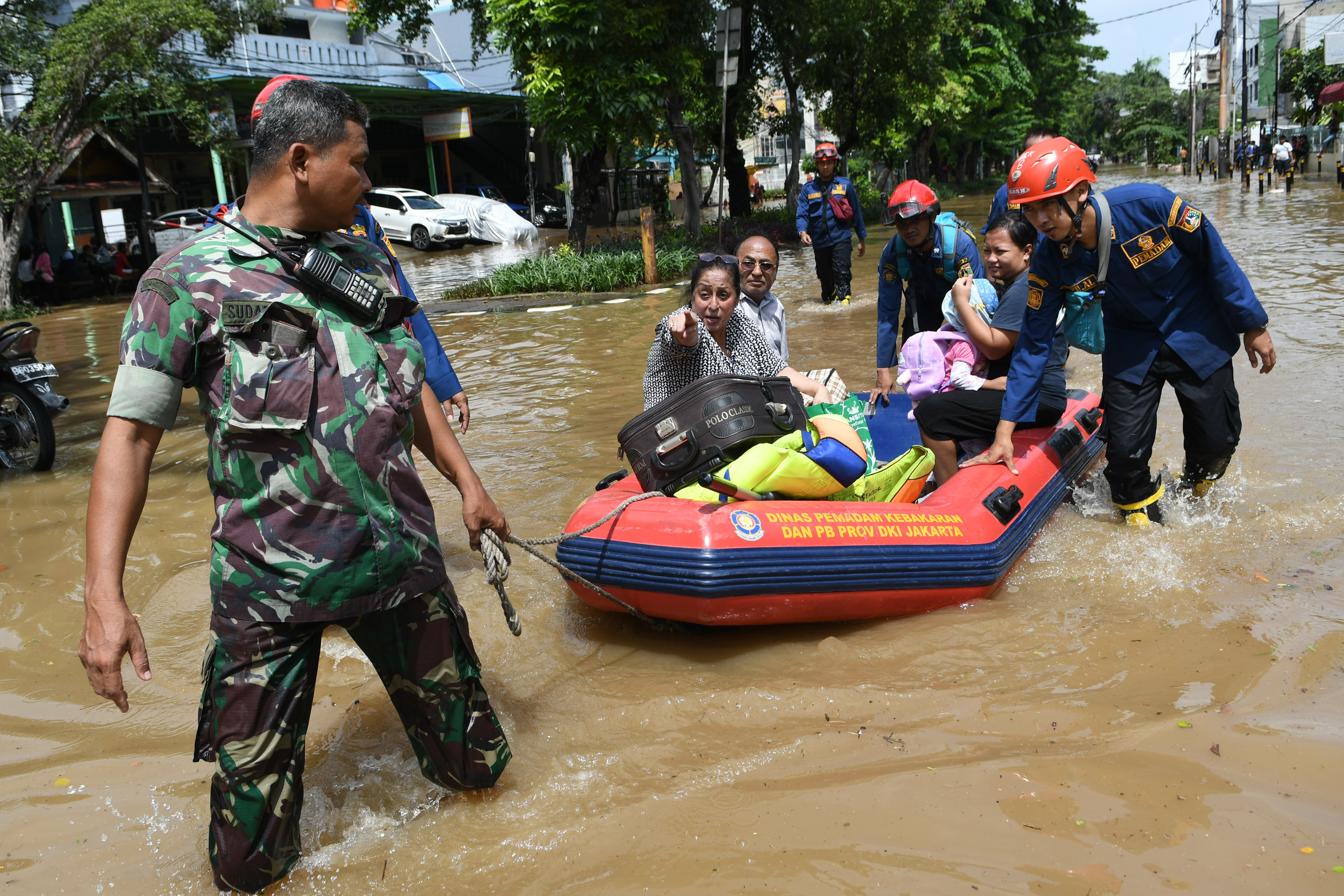 Anggota TNI dan Damkar dan PB DKI Jakarta menarik perahu karet yang dinaiki warga saat banjir di kawasan Bungur Besar Raya, Jakarta
