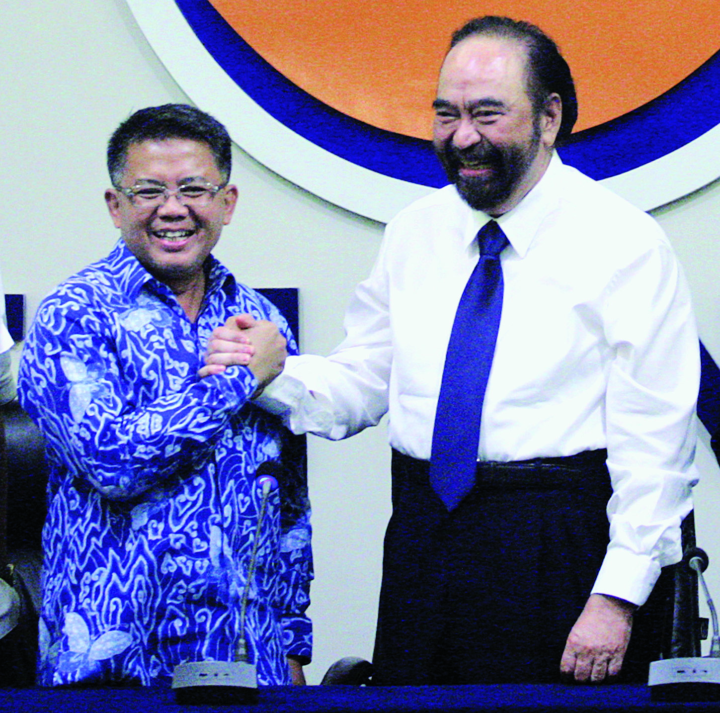 Ketua Umum Partai NasDem Surya Paloh (kanan) berjabat tangan dengan Presiden PKS Sohibul Iman saat konferensi pers.