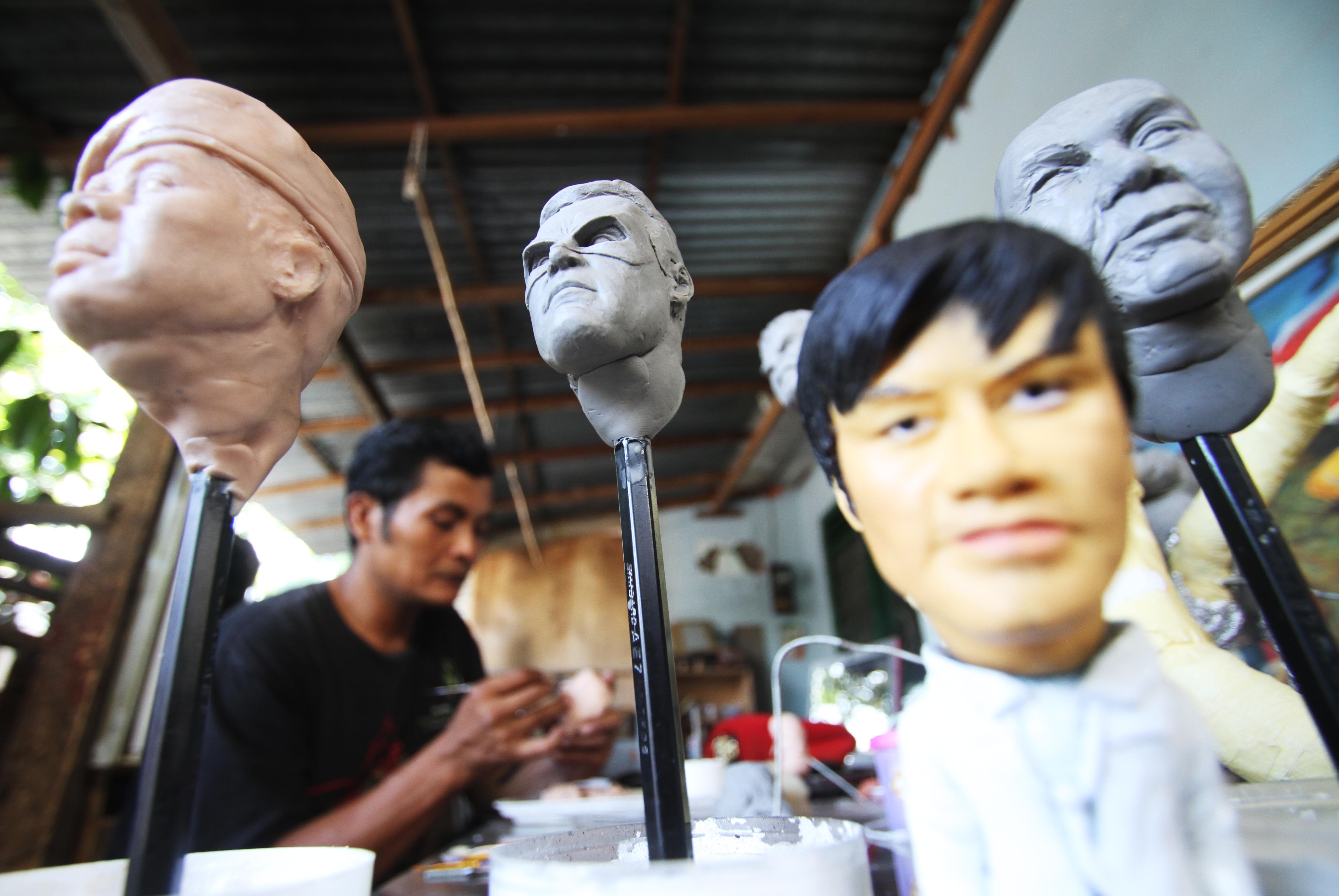  Iwan (37 tahun), mitra usaha UMKM Bank Rakyat Indonesia (BRI), menyelesaikan kerajinan berupa boneka tokoh .