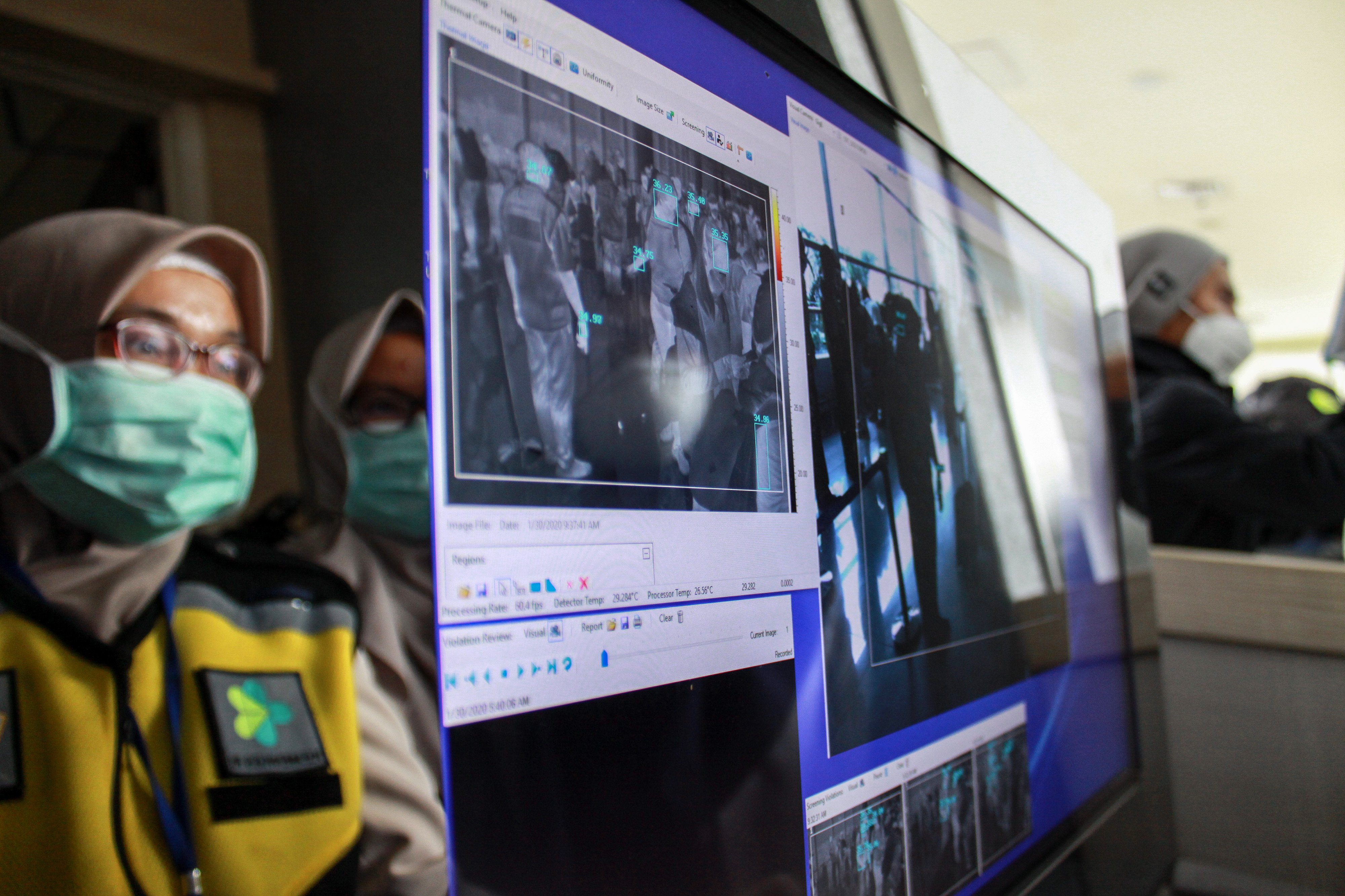 Petugas karantina kesehatan memeriksa penumpang dengan alat pendeteksi suhu tubuh (thermal scanner) di Bandara Juanda Surabaya