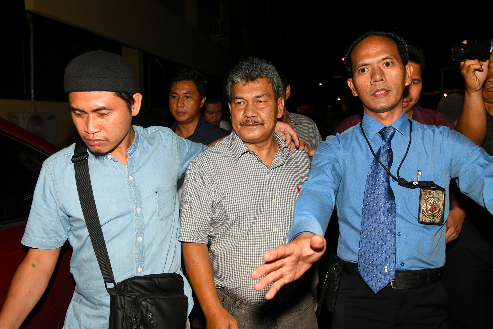 Anggota Ditreskrimsus Polda Sumatera Selatan membawa Wakil Bupati Ogan Komering Ulu Johan Anuar (tengah) usai menjalani pemeriksaan.