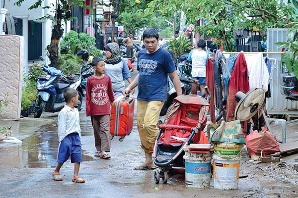 Warga membersihkan barang-barang yang kotor dan rusak akibat terendam banjir di Perumahan Griya Mas Serpong, Tangerang Selatan