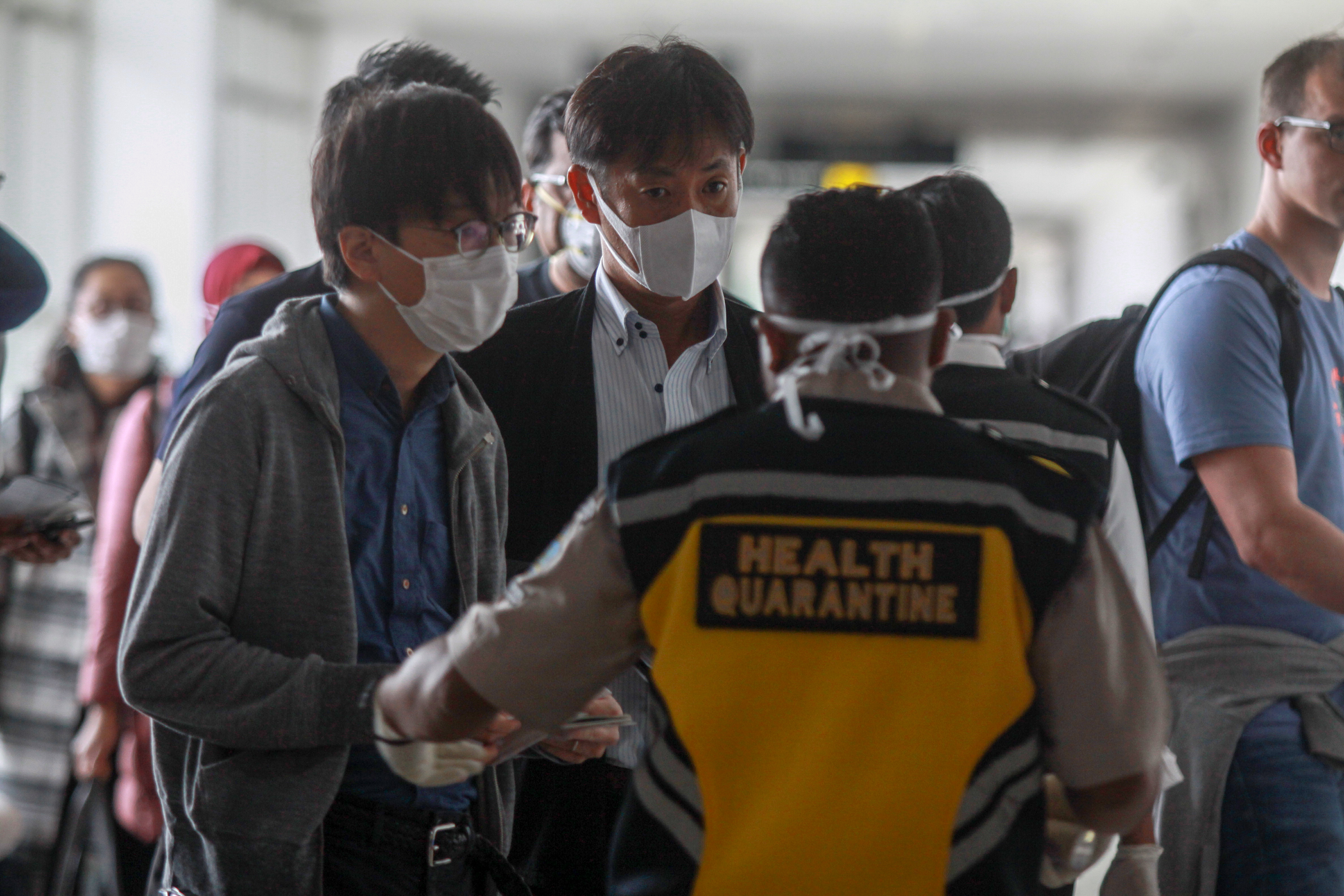 petugas karantina kesehatan memeriksa penumpang di terminal kedatangan Bandara Juanda, Surabaya, Jawa Timur