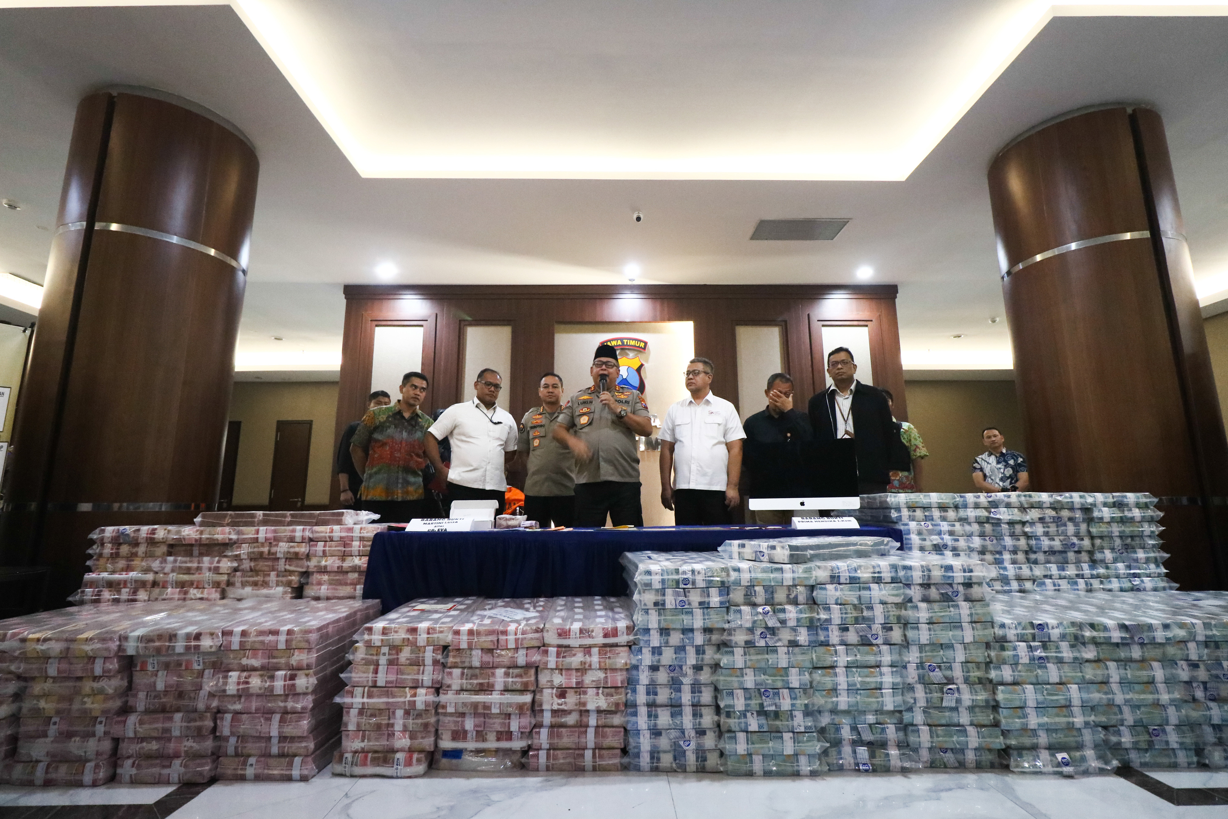 Kapolda Jawa Timur Irjen Luki Hermawan (tengah) menunjukkan barang bukti uang dari kasus MeMiles di Polda Jawa Timur, Jumat (10/1/2020).