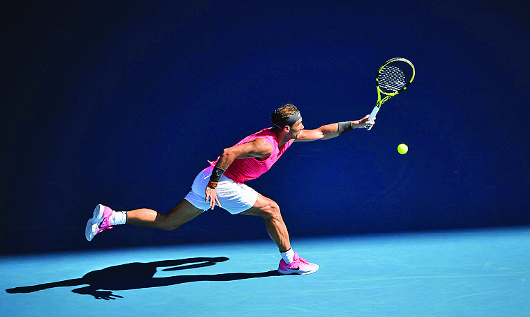 Petenis Spanyol Rafael Nadal memukul bola ke arah rekan senegaranya, Pablo Carreno Busta, dalam laga babak ketiga Australia Terbuka 2020.