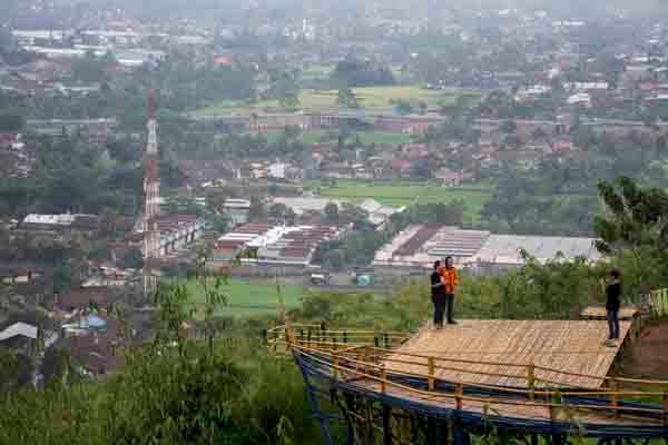 Pengunjung berfoto di kawasan wisata Gunung Sunda, Cisaat, Kabupaten Sukabumi, Jawa Barat, Jumat (15/2/2019). 