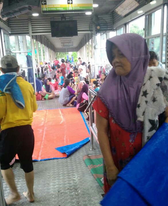 Halte Trans Jakarta Jembatan Baru Jalan Daan Mogot Jakarta Barat dijadikan tempat pengungsian oleh warga.