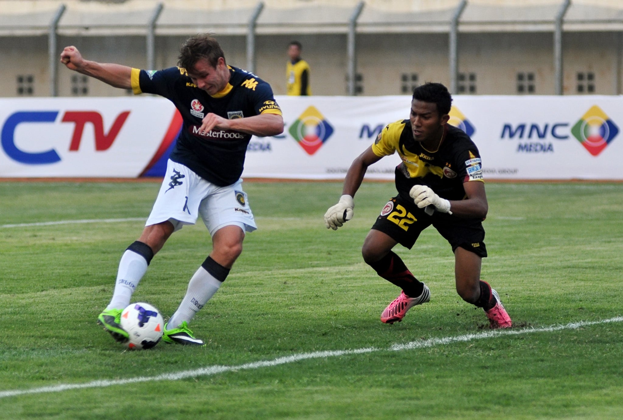 Gelandang Central Coast Mariners Australia Nick Fitzgerald (kiri) berusaha melepaskan tendangan yang dikawal penjaga gawang Teja Paku Alam. 