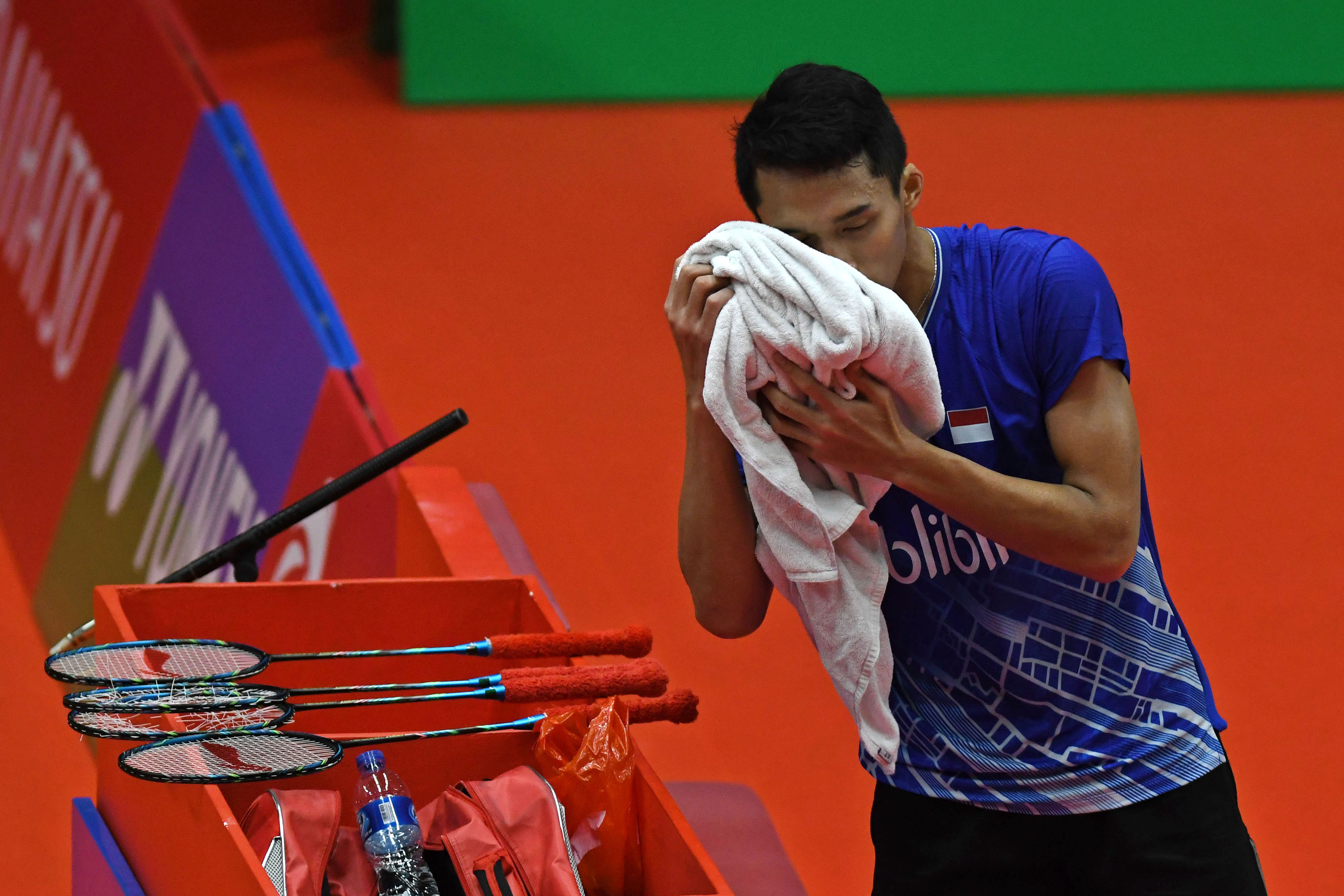 Pebulu tangkis tunggal putra Indonesia Jonatan Christie menyeka keringatnya di sela pertandingan.