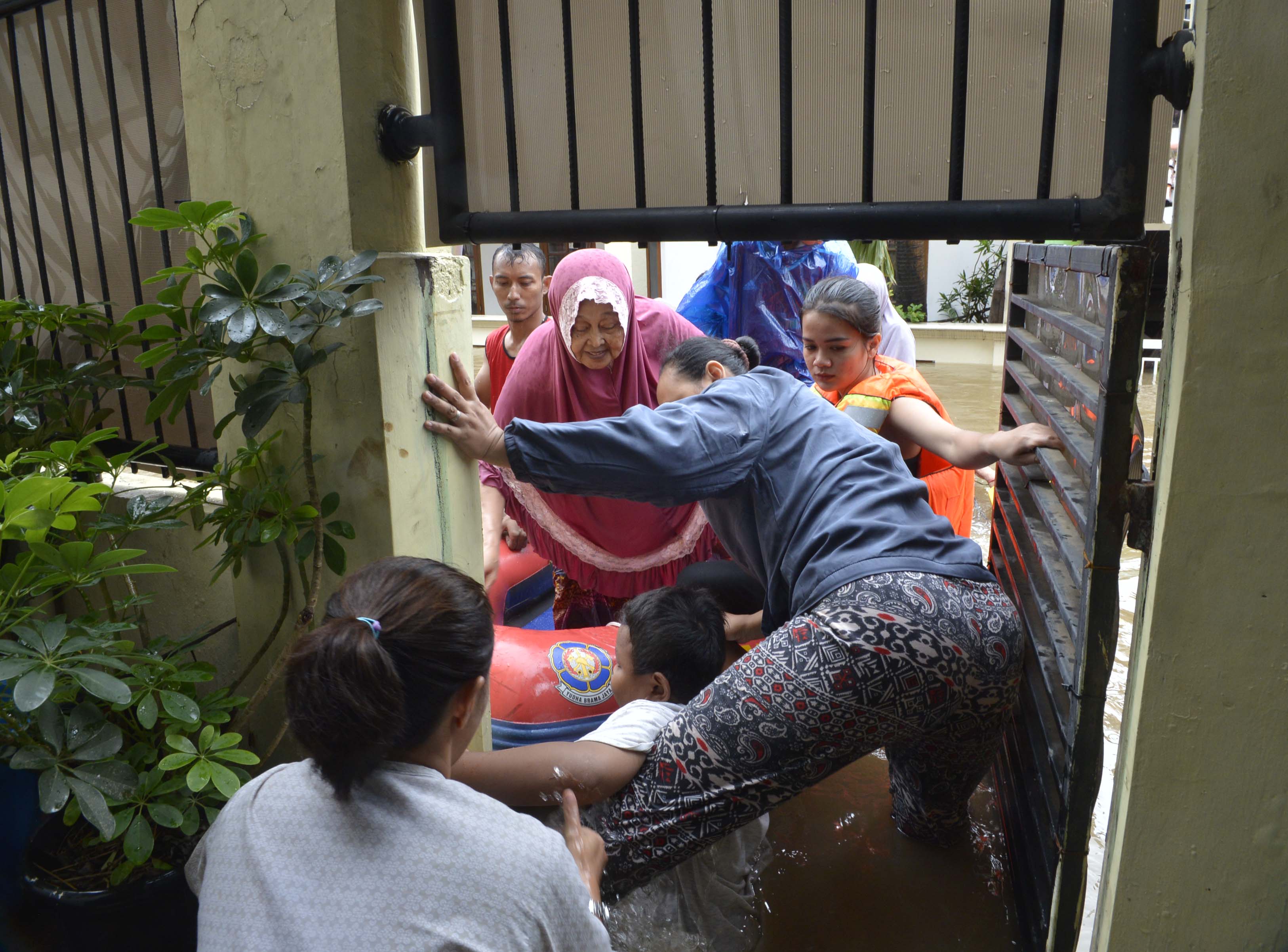 Warga dievakuasi keluar dari rumah yang terkena banjir di Jalan Dato Tonggara, Kramat Jati, Jakarta Timur, Rabu (1/1).
