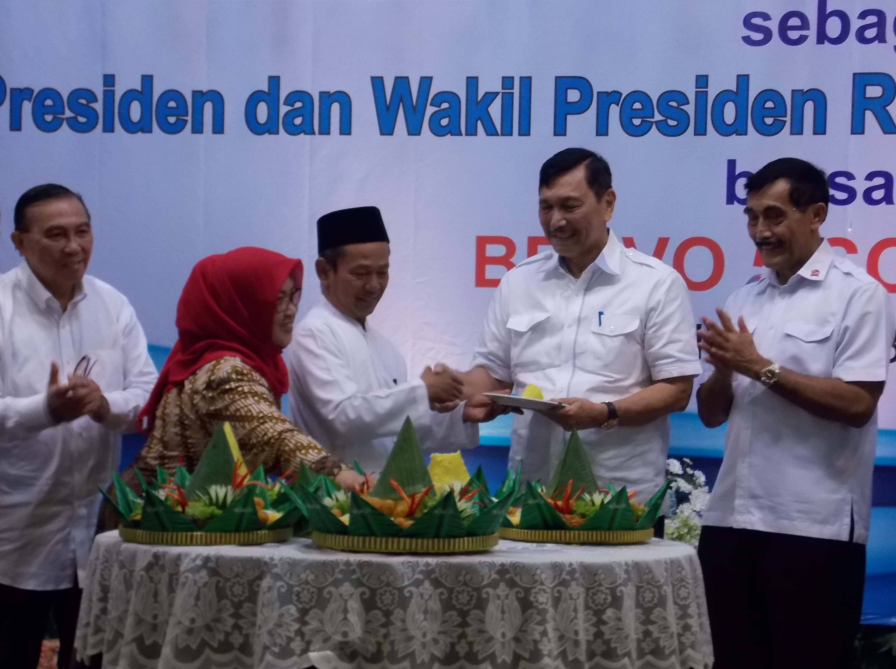 Pembina kelompok relawan Bravo V, Luhut Binsar Panjaitan, menerima potongan tumpeng pertama dalam syukuran kemenangan Jokowi-Ma'ruf Amin.