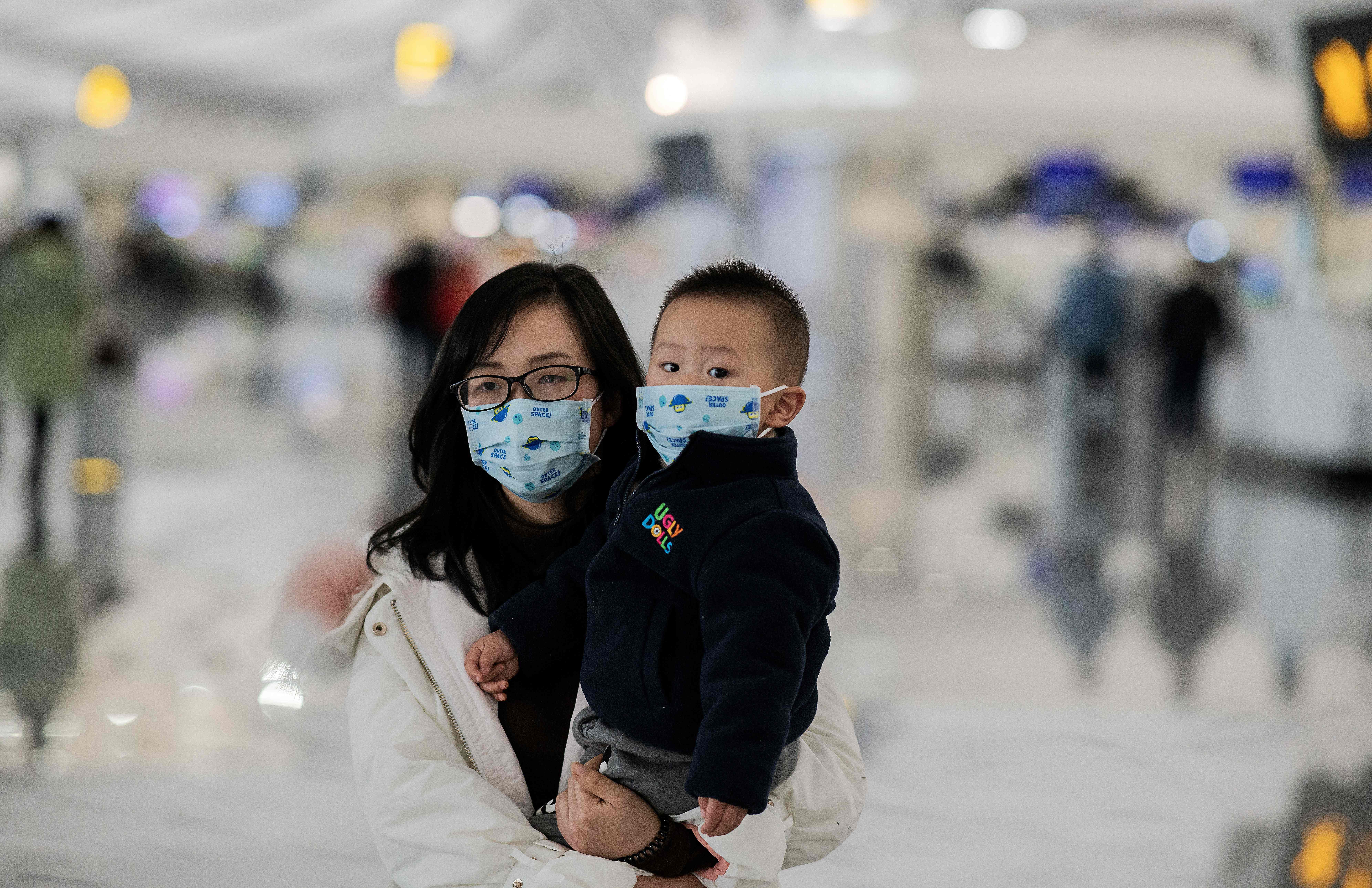 Seorang perempuan dan anak mengenakan masker di Bandara Internasional Daxing, Beijing