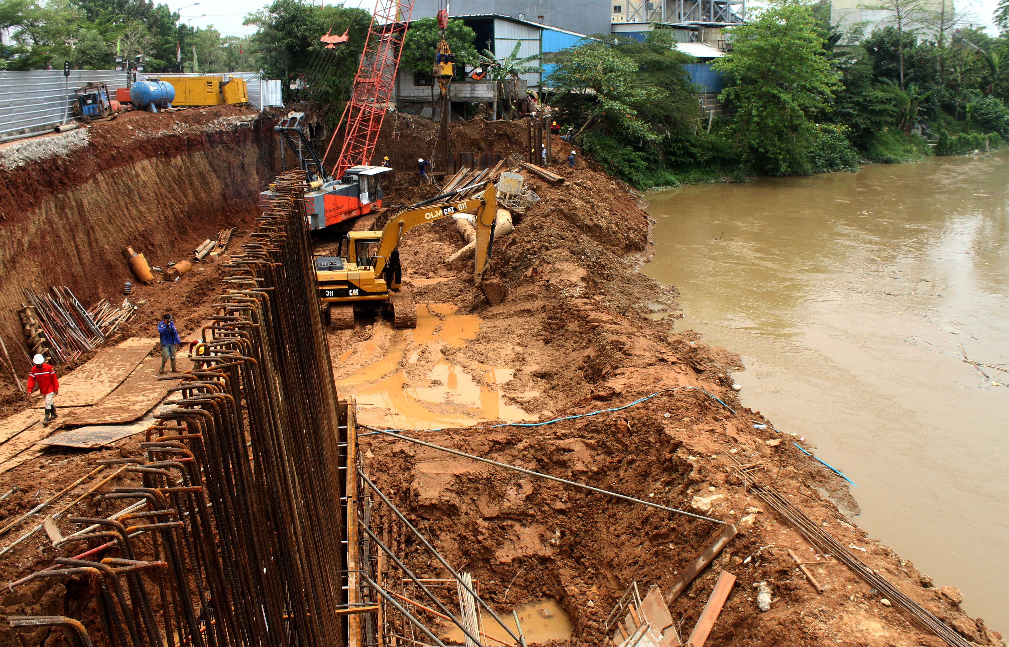 Pekerja beraktivitas di area proyek perbaikan tanggul sungai yang amblas, di kawasan Cipendawa, Bekasi, Jawa Barat.
