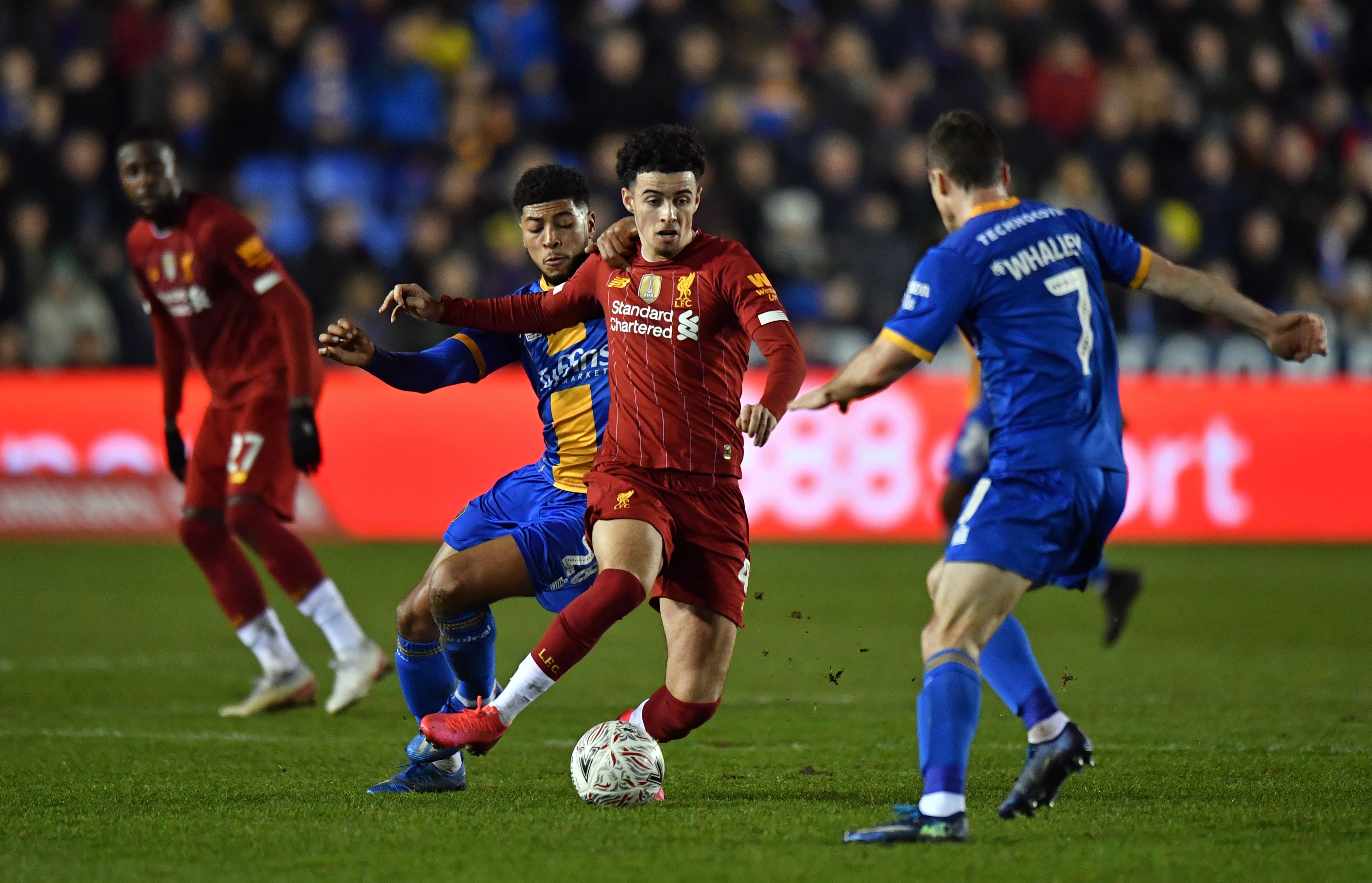 Gelandang Liverpool Curtis Jones berusaha melewati hadangan dua pemain Shrewsbury Town