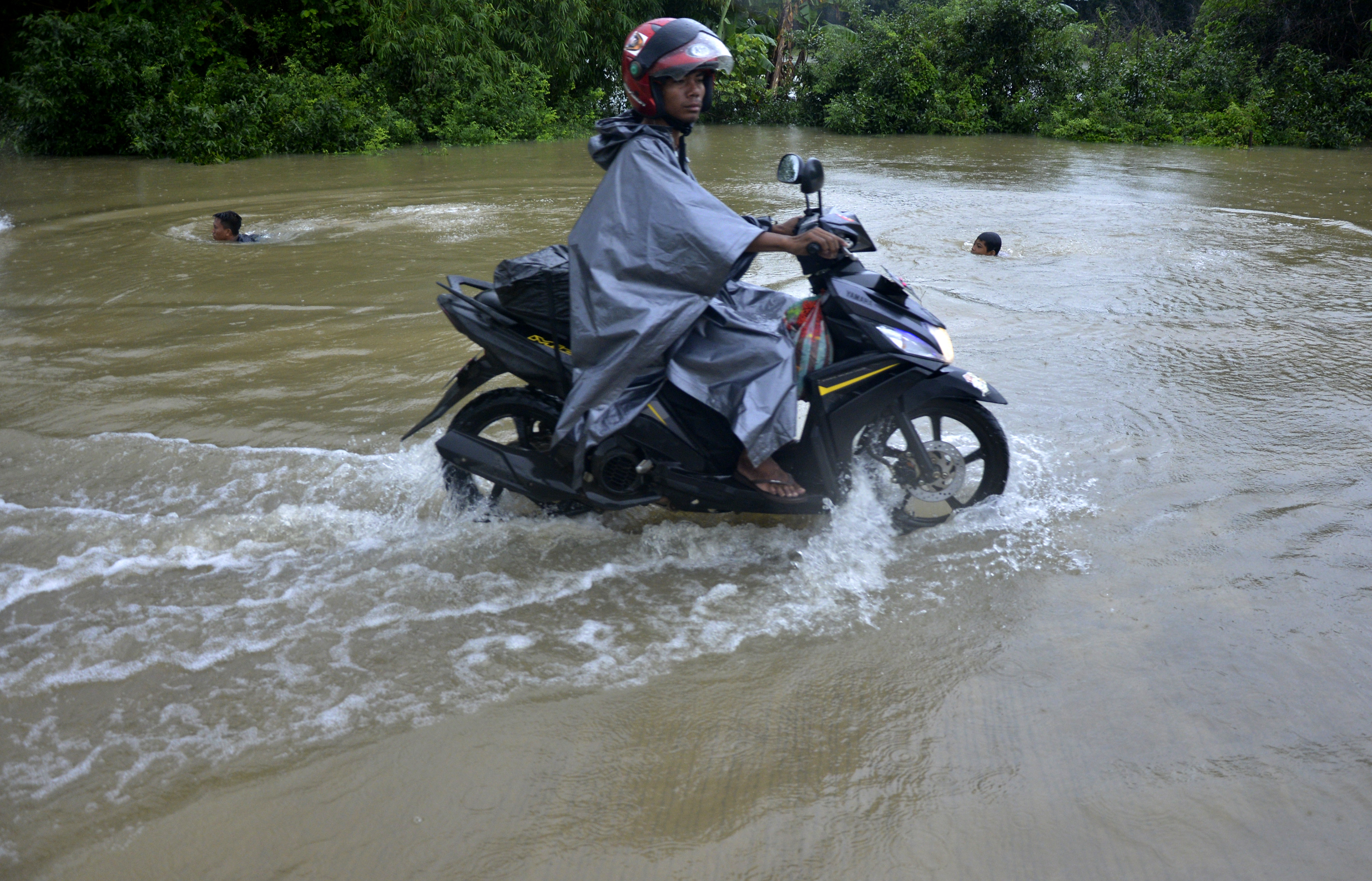  Pengendara berusaha menerobos banjir yang menggenangi ruas jalan Kelurahan Katimbang, Makassar, Sulawesi Selatan, Minggu (12/1)