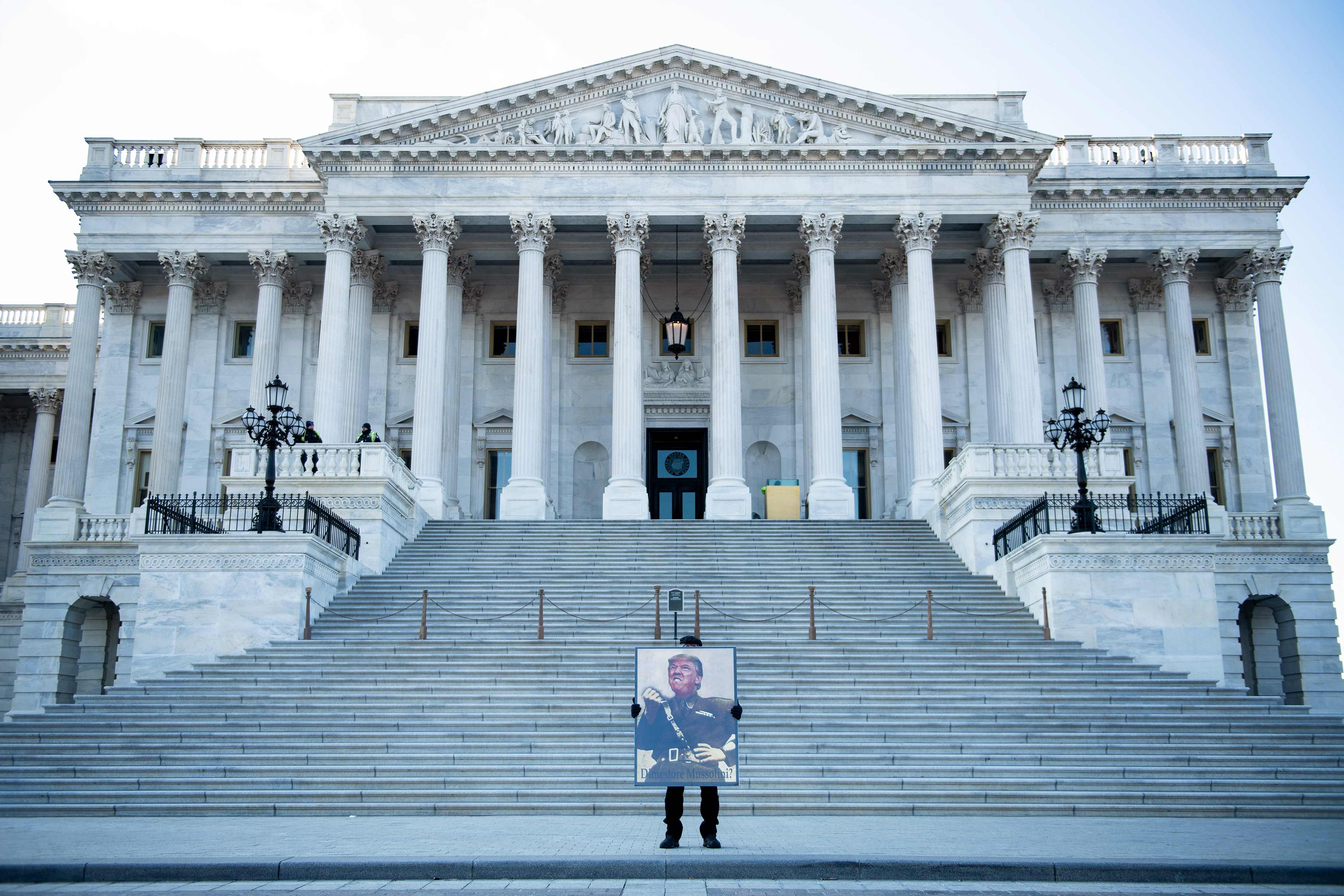 Pengunjuk rasa berdiri di depan Capitol Hill yang gelar pengadilan impeachment Presiden Dinald Trump