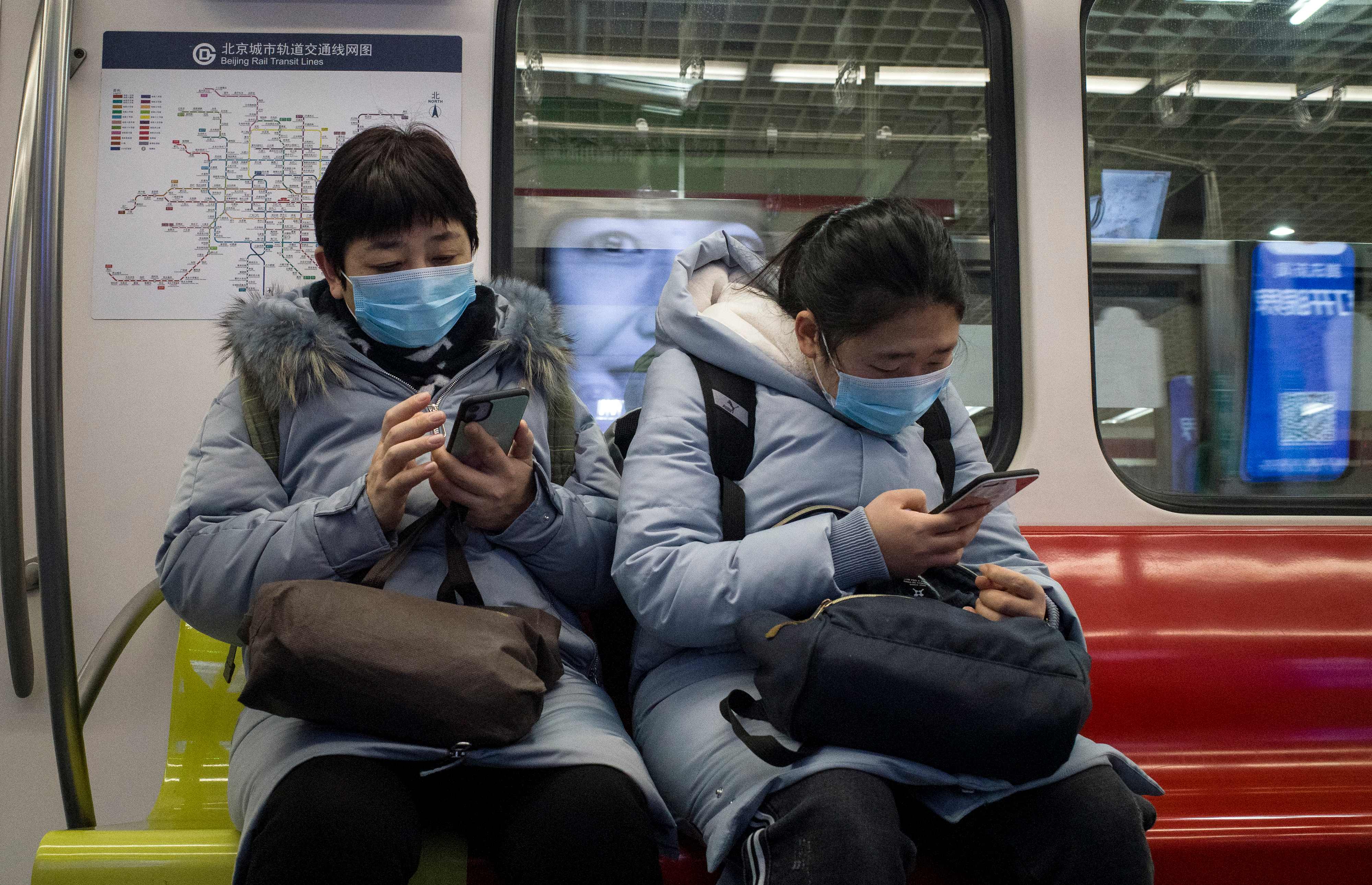 Warga Beijing mengenakan masker saat menaiki kereta api untuk mencegah penyebaran virus korona.