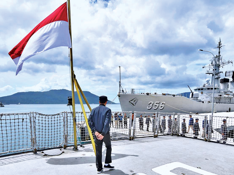 Presiden Joko Widodo berjalan di atas KRI Usman Harun sambil melihat KRI Karel Satsuit Tubun-356 yang bersandar di Puslabuh TNI-AL .