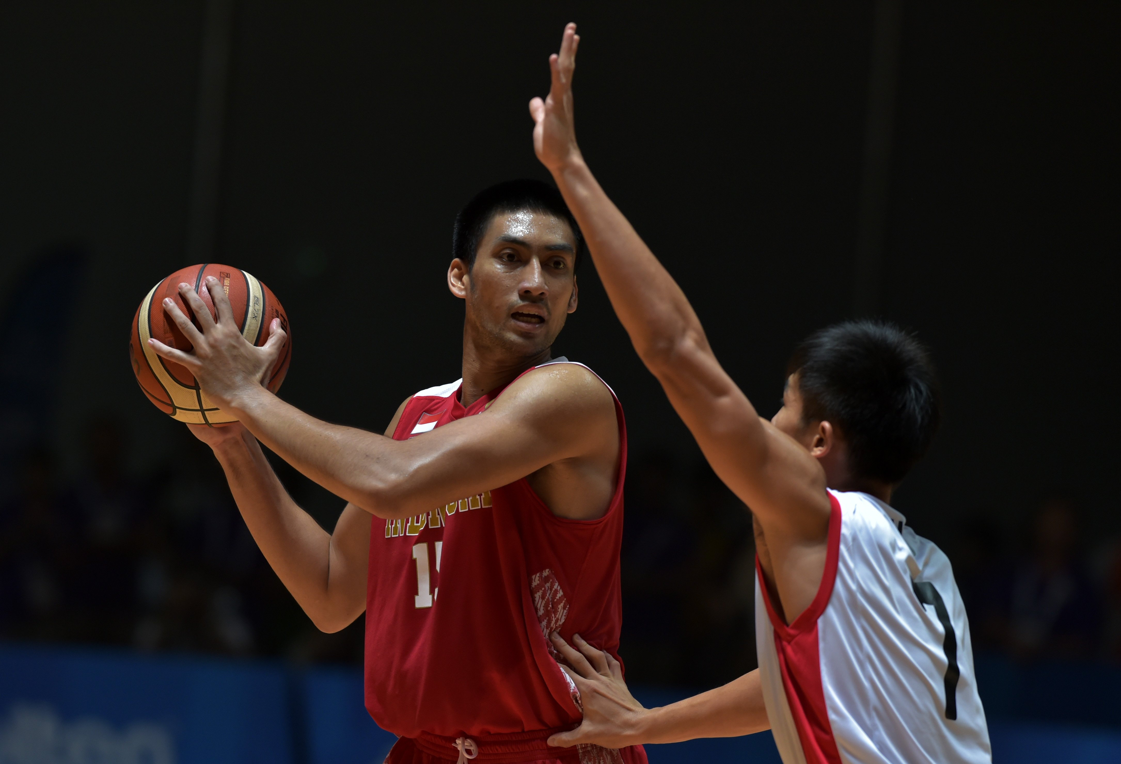  Pebasket putra Indonesia Christian Ronaldo Sitepu (kiri) berebut bola dengan pebasket Singapura Qingde Wu  