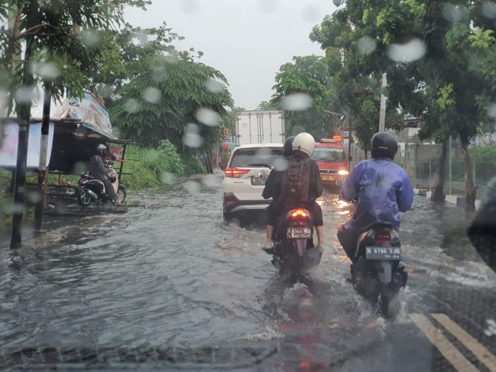 Pengendara melintasi banjir di wilayah Meruya, Jakarta Barat, Selasa (1712)