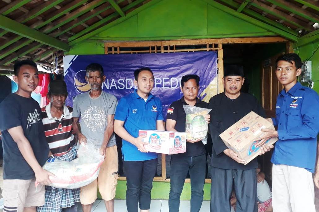 Ketua NasDem Karawang Dian Fahrud Jaman (tengah) menyerahkan bantuan sembako kepada warga korban banjir