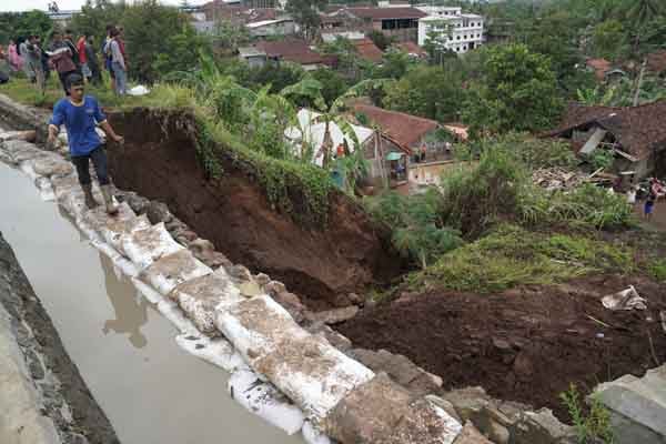 ilustrasi : Relawan melintasi tanggul darurat yang dipasang di lokasi longsor tanggul irigasi di Kelurahan Parakancanggah, Banjarnegara.