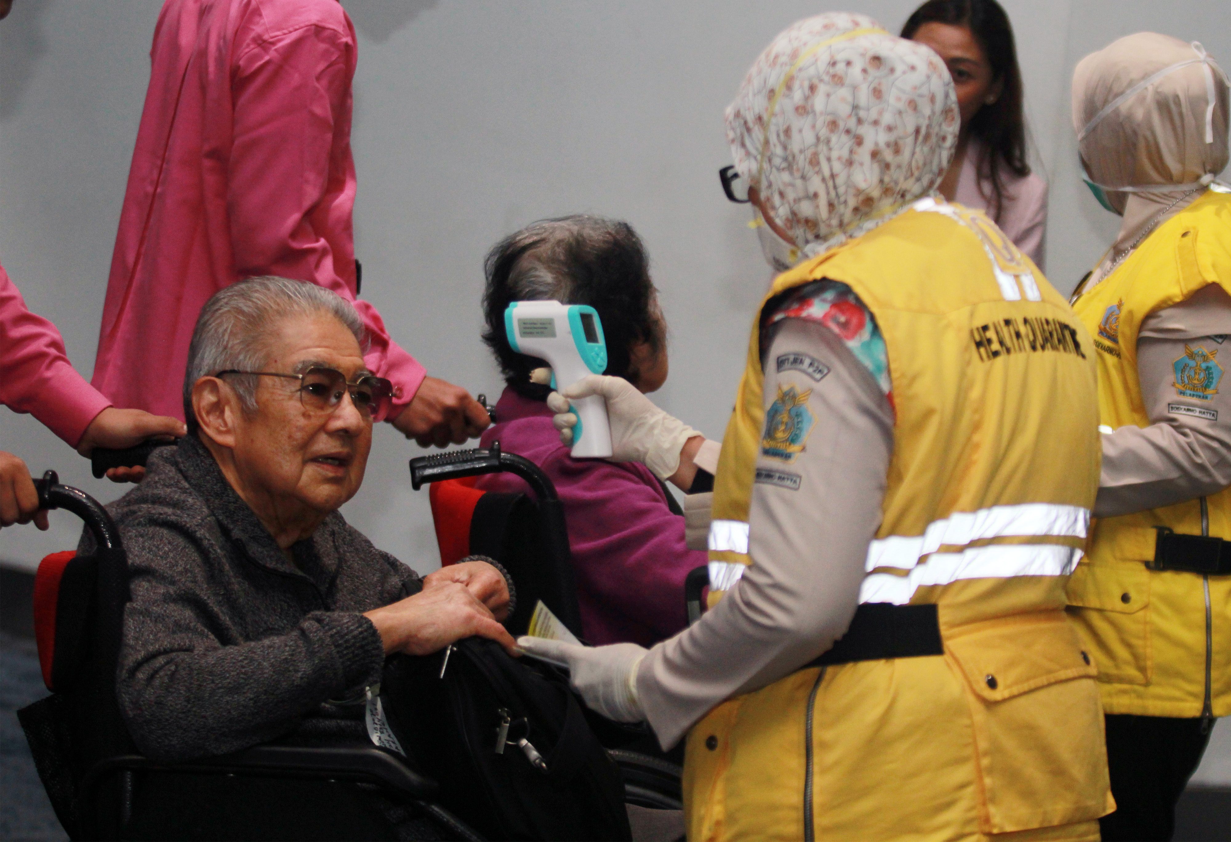 Petugas Kesehatan Karantina Bandara Soekarno Hatta melakukan pemeriksaan acak suhu badan penumpang yang baru mendarat.