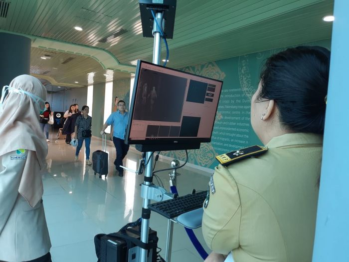 Petugas mengawasi para penumpang pesawat yang tiba di Bandara Sultan Mahmud Badaruddin, Palembang, Sumatera Selatan, melalui thermoscan. 