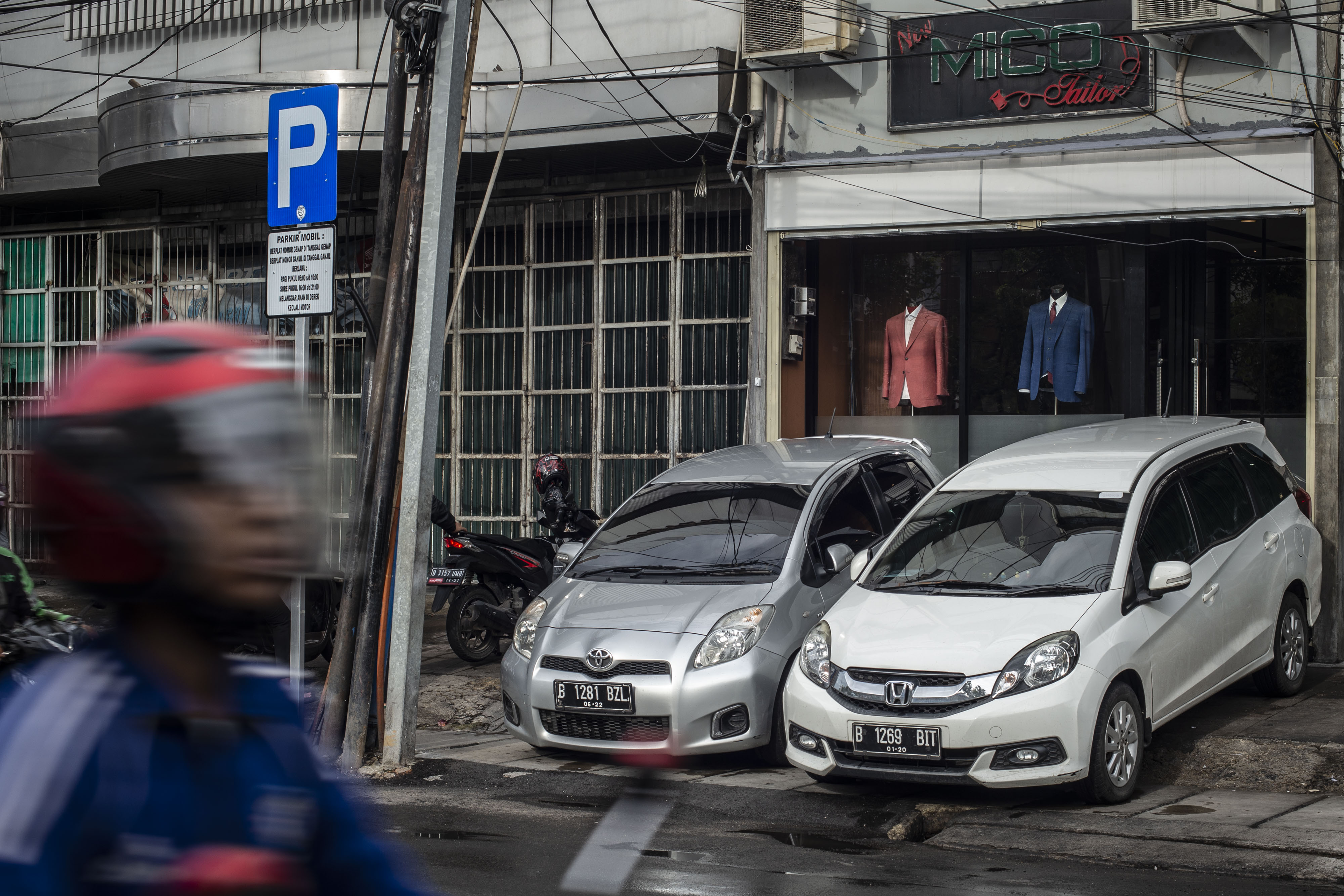 Dua mobil terparkir di trotoar Jalan Hayam Wuruk, Jakarta.