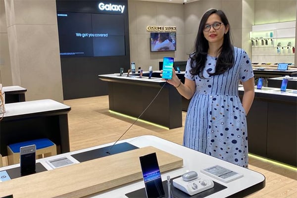 Seorang pramuniaga sedang memamerkan smartphone terbaru.