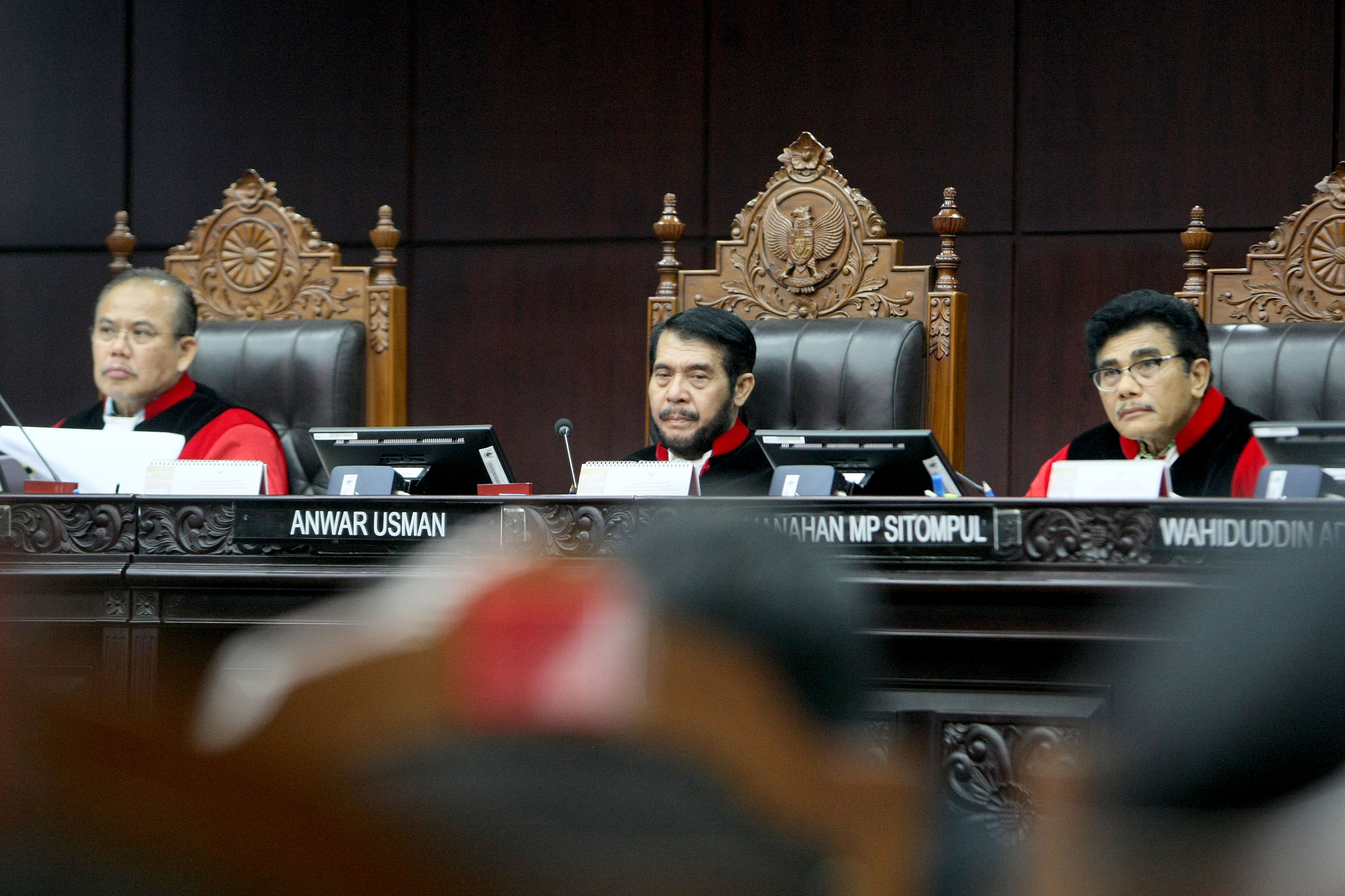 Ketua Mahkamah Konstitusi, Anwar Usman (tengah), memerhatikan keterangan perwakilan DPR dan pemerintah terkait uji materil UU KPK.