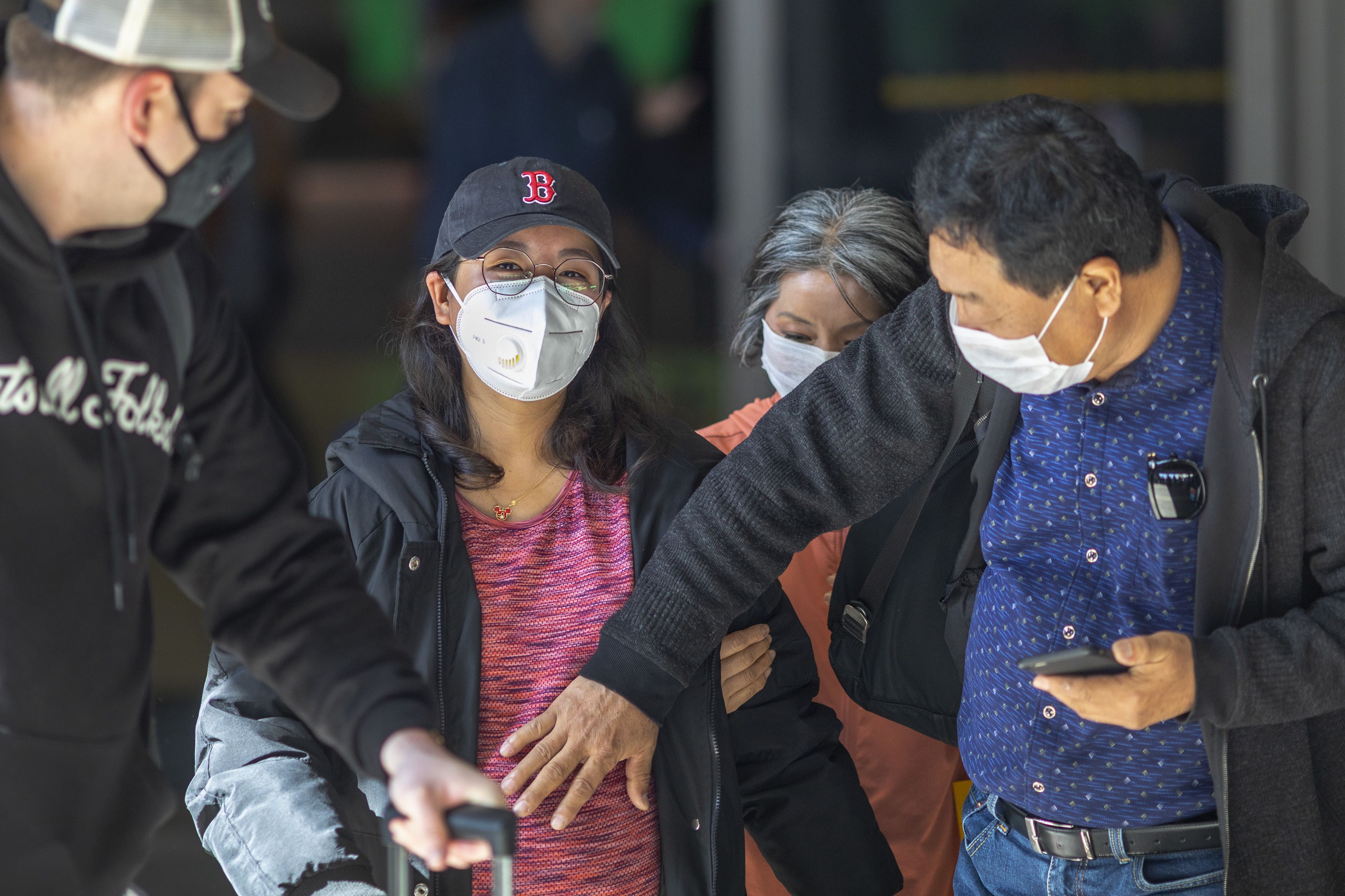 Para penumpang pesawat tiba di Bandara Los Angeles, AS mengenakan masker untuk mencegah penularan virus korona. 