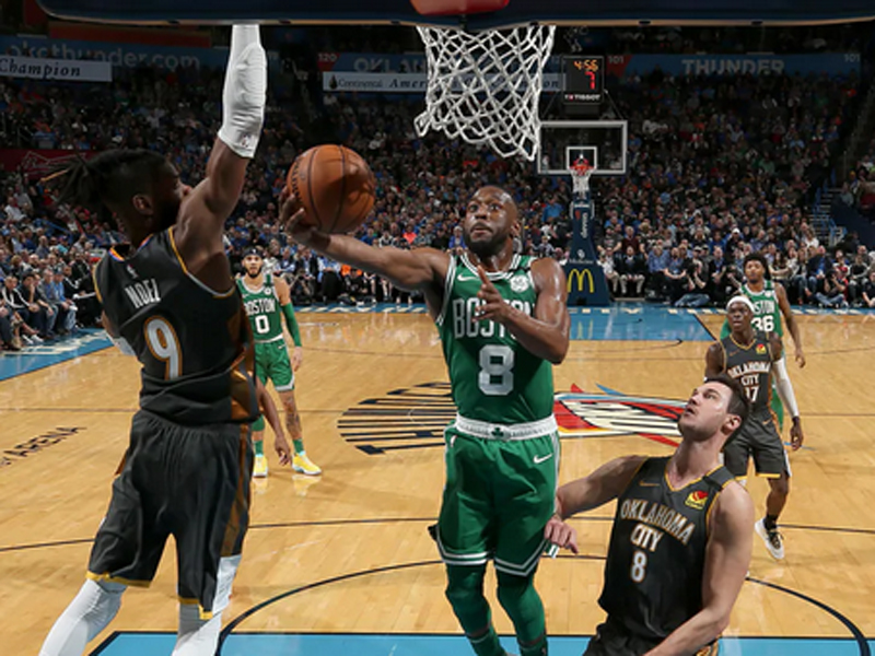 Kemba Walker (tengah) melakukan lay up dalam laga NBA antara Boston Celtics dan Oklahoma City Thunder