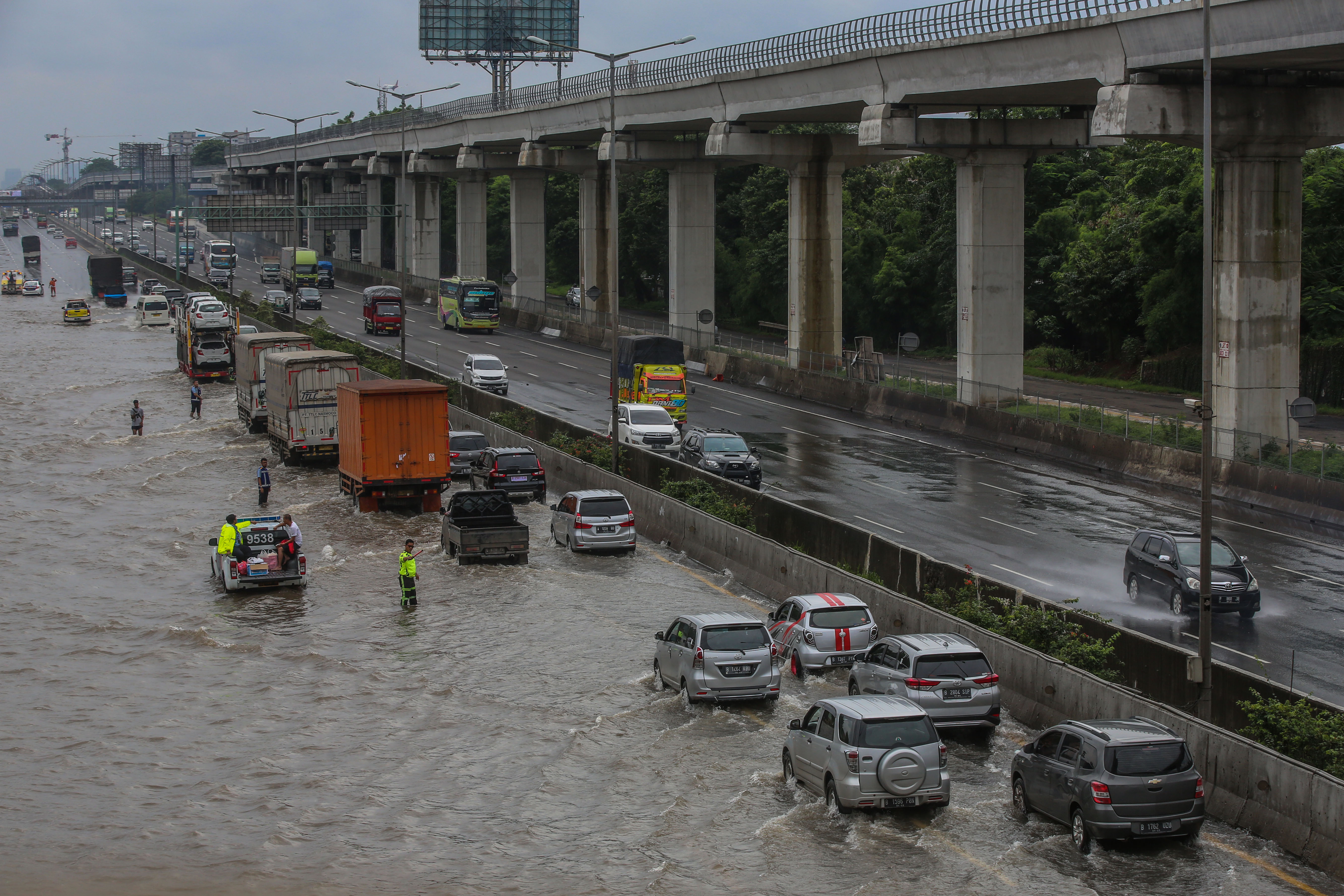 Pengendara memperlambat laju kendaraan saat melewati banjir  ruas tol Jakarta-Cikampek KM 09 kawasan Jatibening, Bekasi, Selasa (25/2/2020).