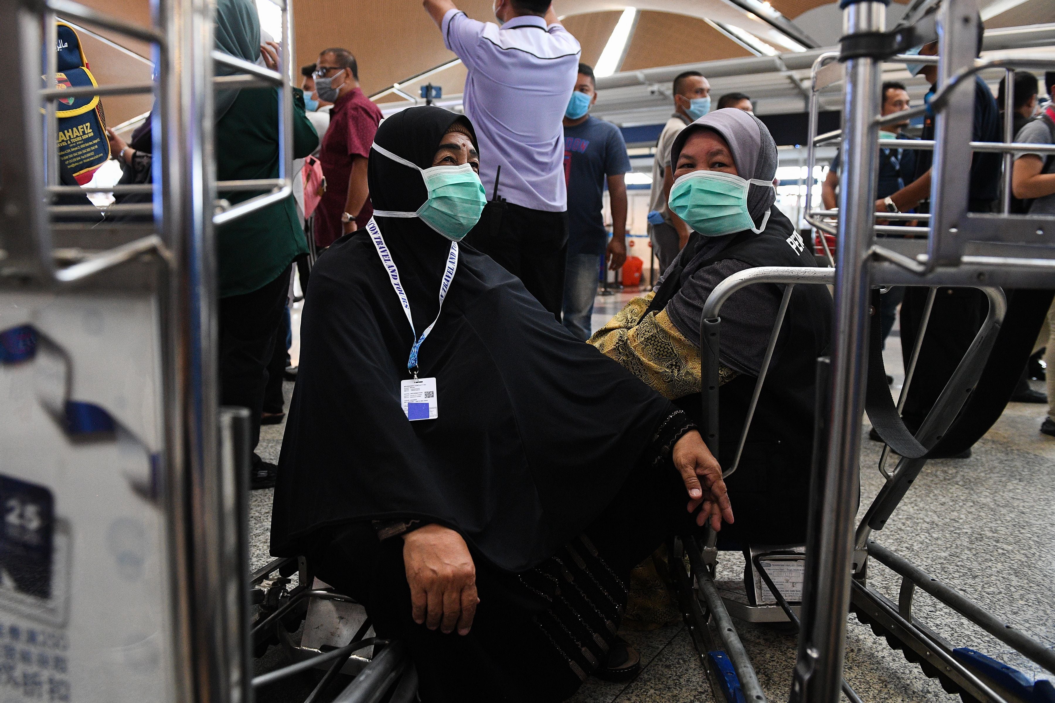 Sejumlah calon penumpang mengenakan masker saat berada di Bandara Internasional Kuala Lumpur di Sepang, Malaysia