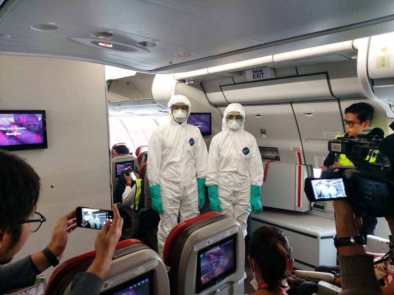 Tim penjemput WNI mengenakan pakaian pelindung di dalam pesawat yang akan bertolak ke Tiongkok dari Bandara Soekarno-Hatta.