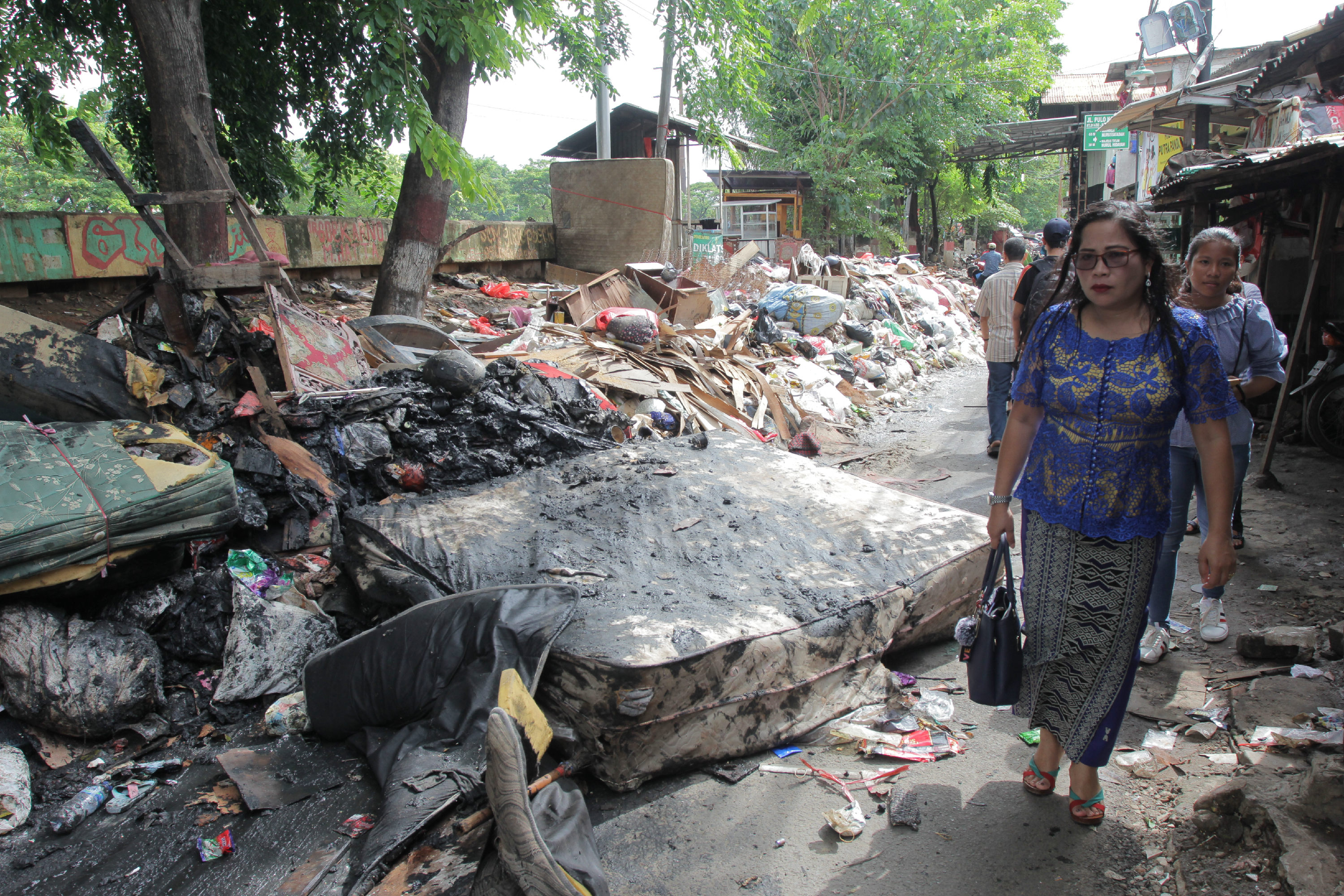Sampah pasca banjir terhampar di sepanjang jalan kawasan Rawa Buaya, Cengkareng, Jakarta Barat.