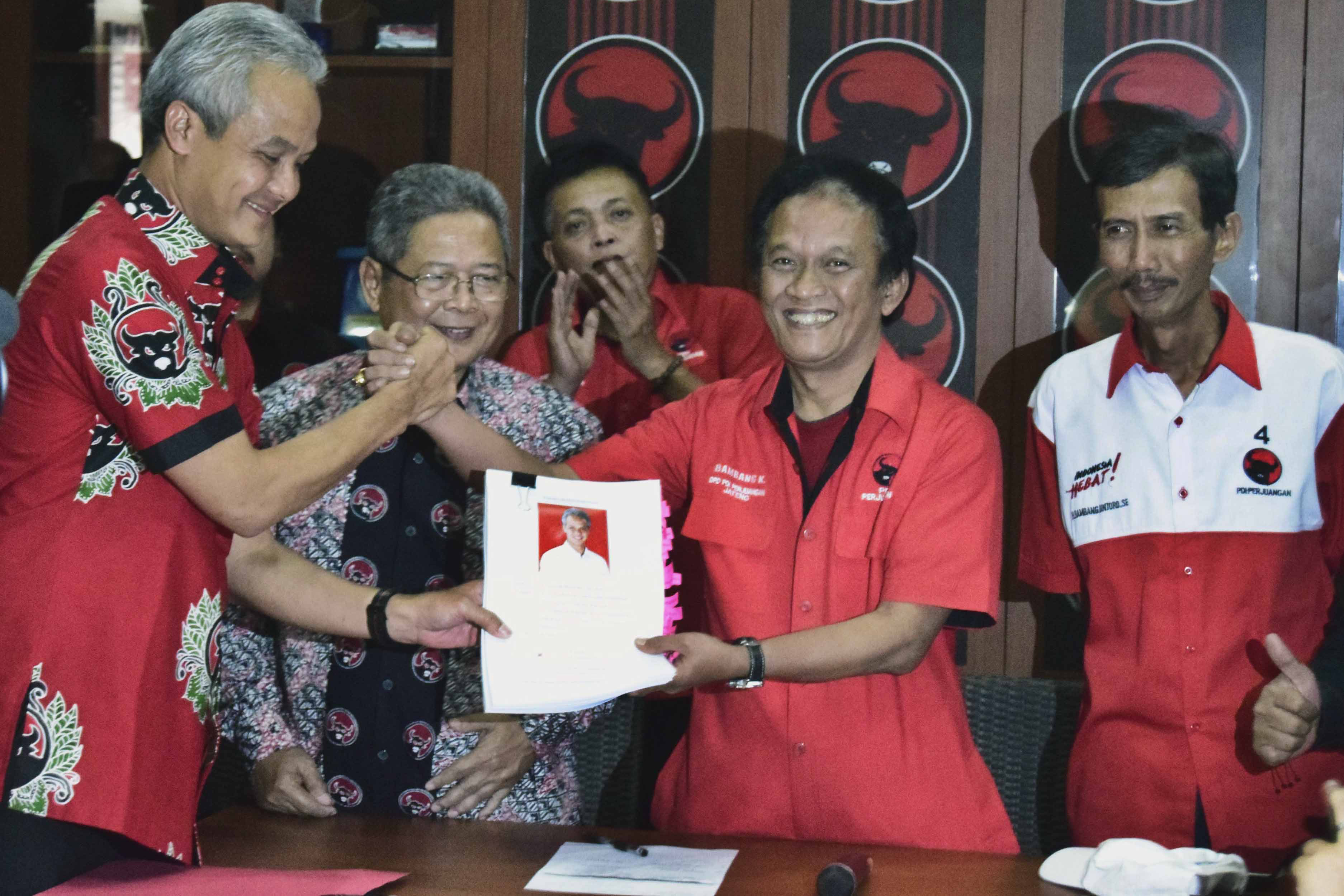 Ganjar Pranowo (kiri) menyerahkan berkas pendaftaran bakal calon gubernur yang diterima Bambang Kusriyanto (kedua kanan).