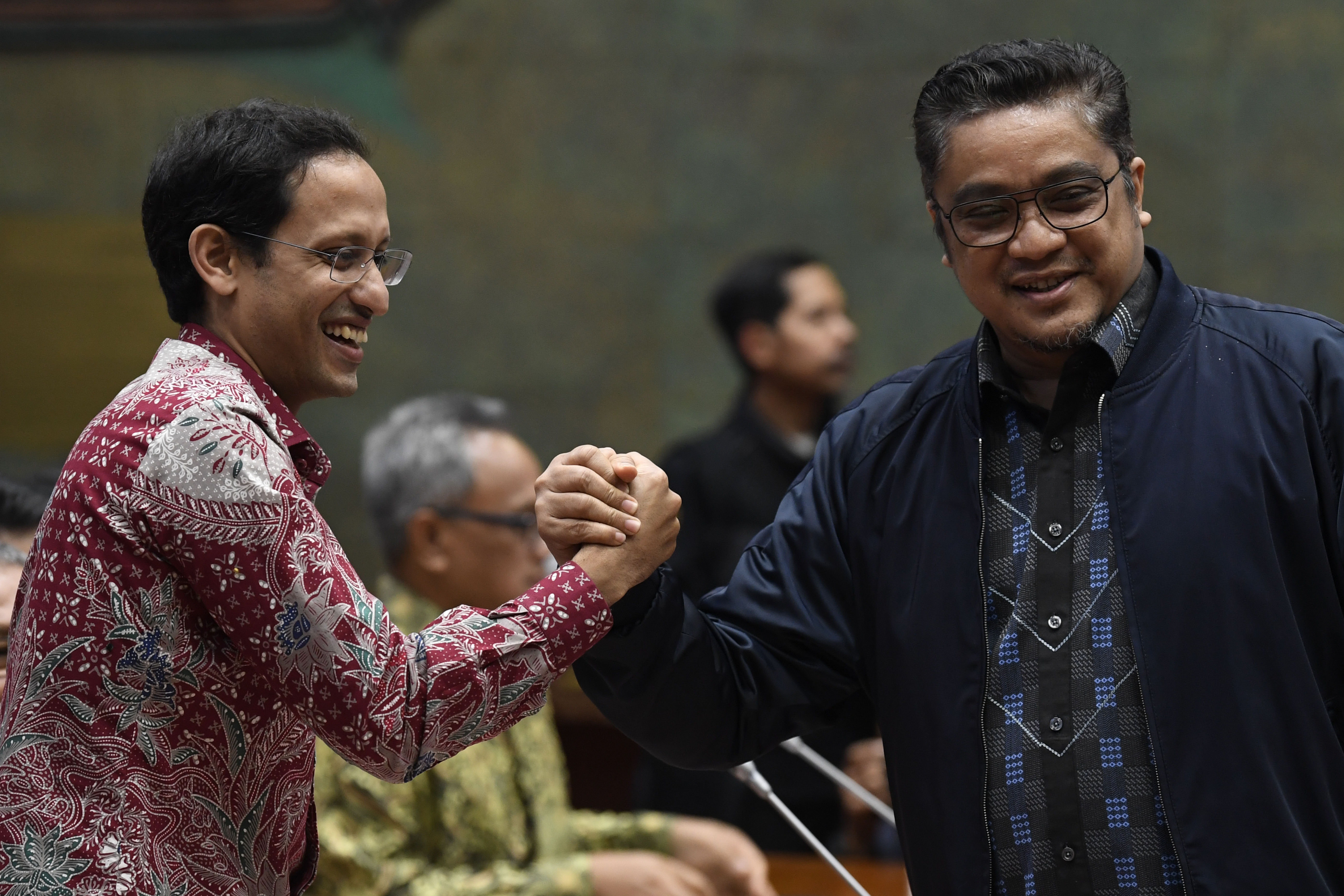 Menteri Pendidikan dan Kebudayaan Nadiem Makarim (kiri) berjabat tangan dengan Wakil Ketua Komisi X DPR Dede Yusuf. 