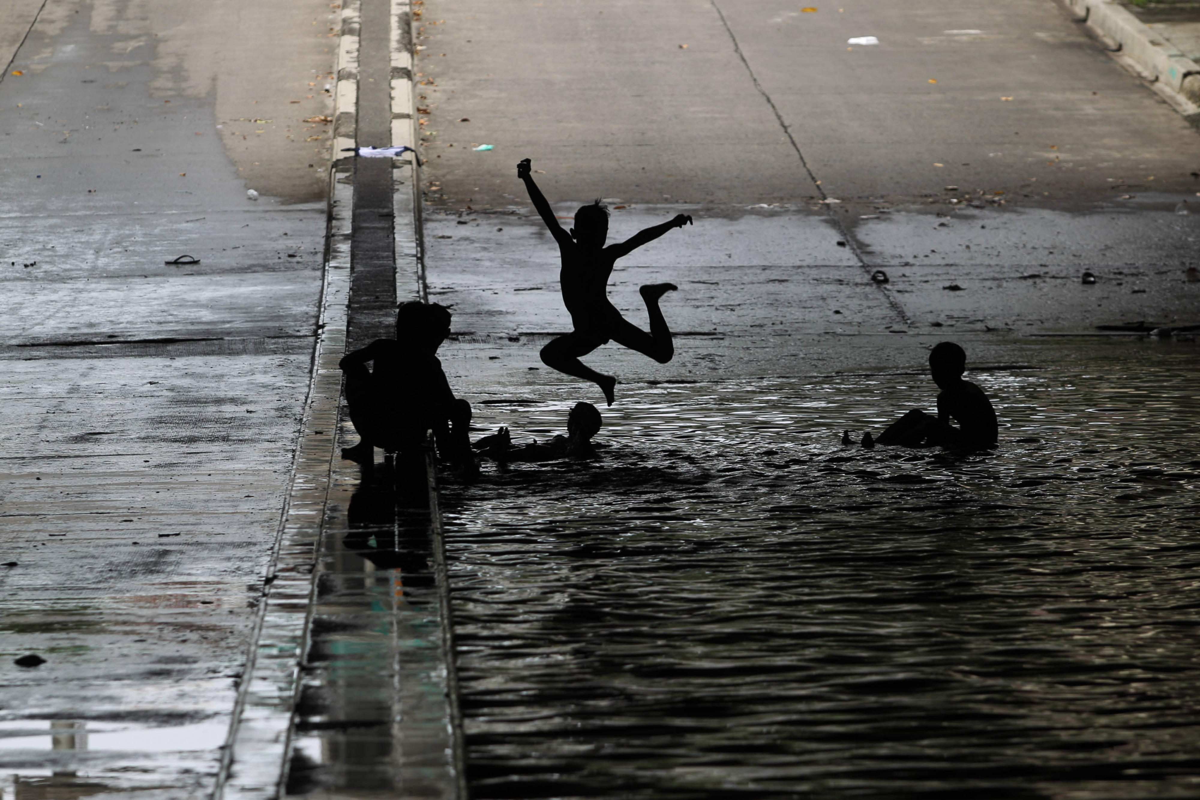Anak-anak bermain air sisa banjir di underpass Kemayoran, Jakarta, Minggu (2/2/2020). 