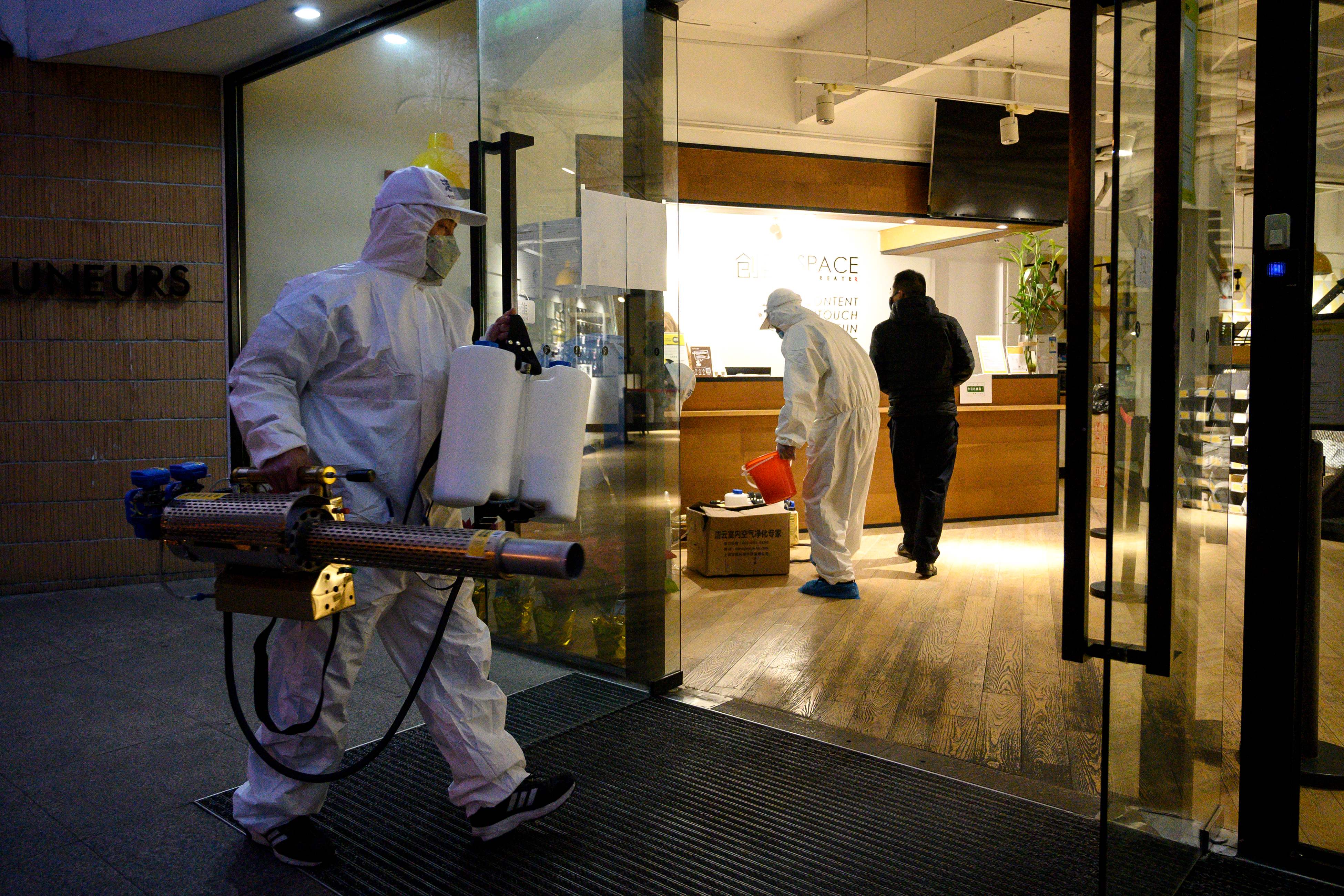  Seorang petugas membawa mesin pengasap untuk mensterilkan pusat bisnis di Shanghai, Tiongkok, sebagai langkah melawan wabah virus korona.