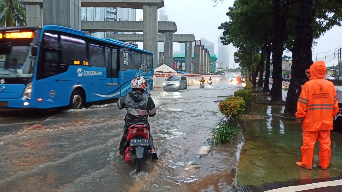 Sejumlah kendaraan berjalan perlahan saat melewati genangan air yang merendam Jalan Rasuna Said, Kuningan, Jakarta Selatan, Selasa (25/2)