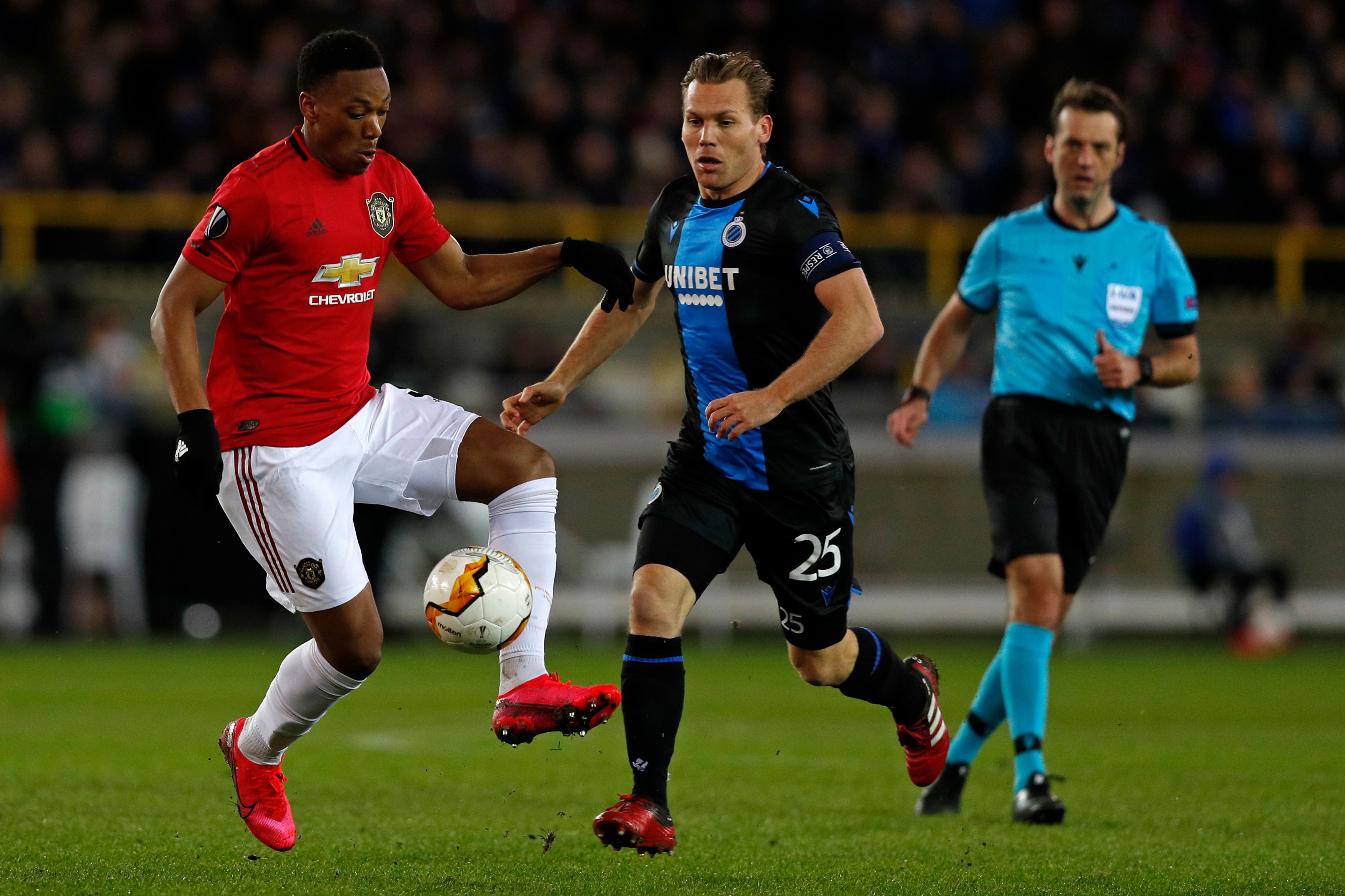 Striker Anthony Martial (L)sedang berebut bola dengan Ruud Vormer pemainClub Brugge's