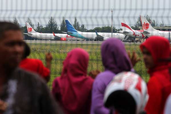 Ilustrasi -- Warga menyaksikan pesawat di Bandara Internasional Sultan Iskandar Muda, Banda Aceh, Aceh, Sabtu (24/10)