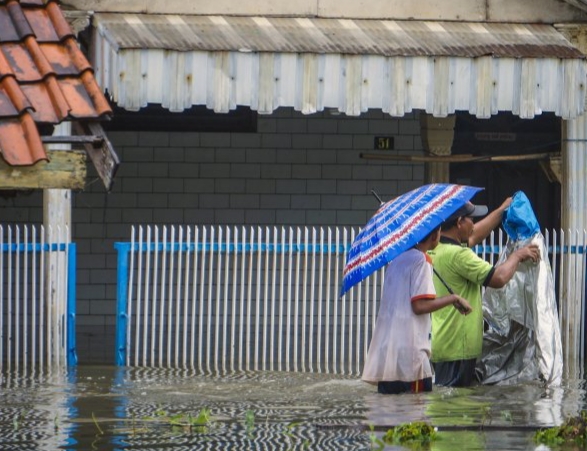 Warga melintasi banjir di Tirto, Pekalongan, Jawa Tengah, Kamis (20/2/2020).